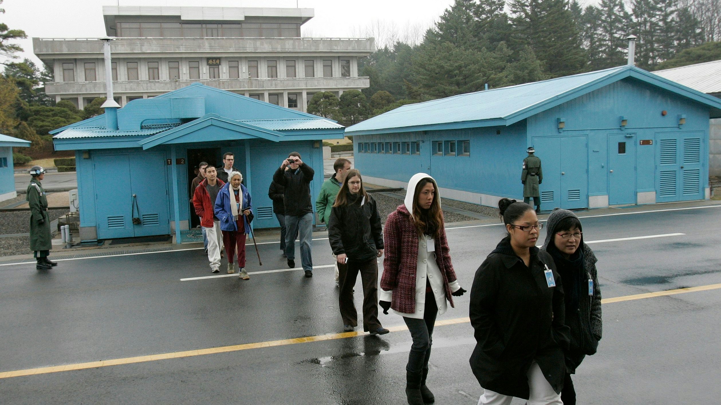 Foreign tourists look around the south side of the truce village of Panmunjom in the demilitarised zone separating the two Koreas in Paju, about 55 km (34 miles) north of Seoul, March 26, 2009. North Korea has put a long-range missile in place for a launch the United States warned would violate U.N. sanctions already imposed on the reclusive state for past weapons tests.  REUTERS/Jo Yong-Hak (SOUTH KOREA POLITICS MILITARY TRAVEL)