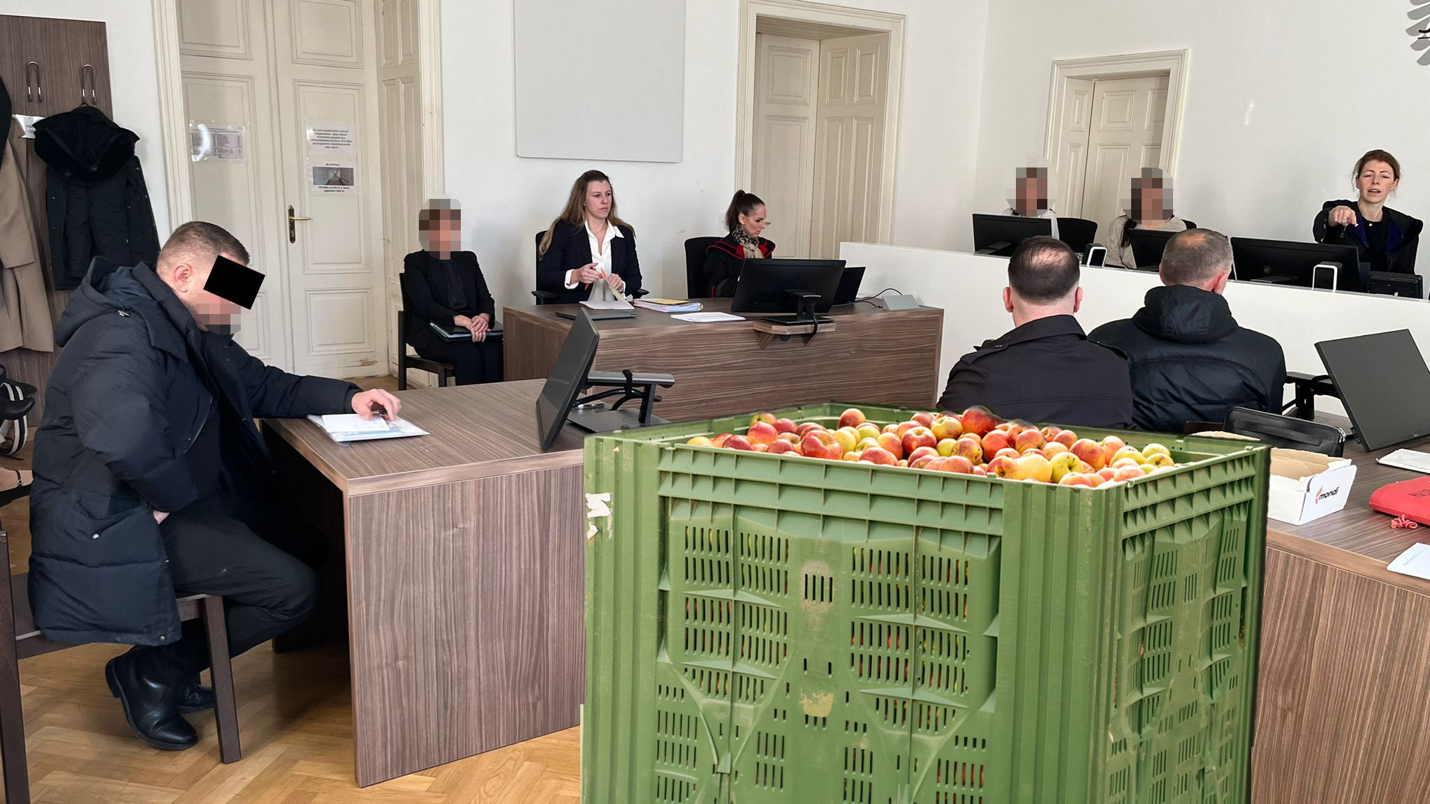 Die Angeklagten im Gerichtssaal; die drei Männer sollen kistenweise Obst einer Firma selbst verkauft haben.