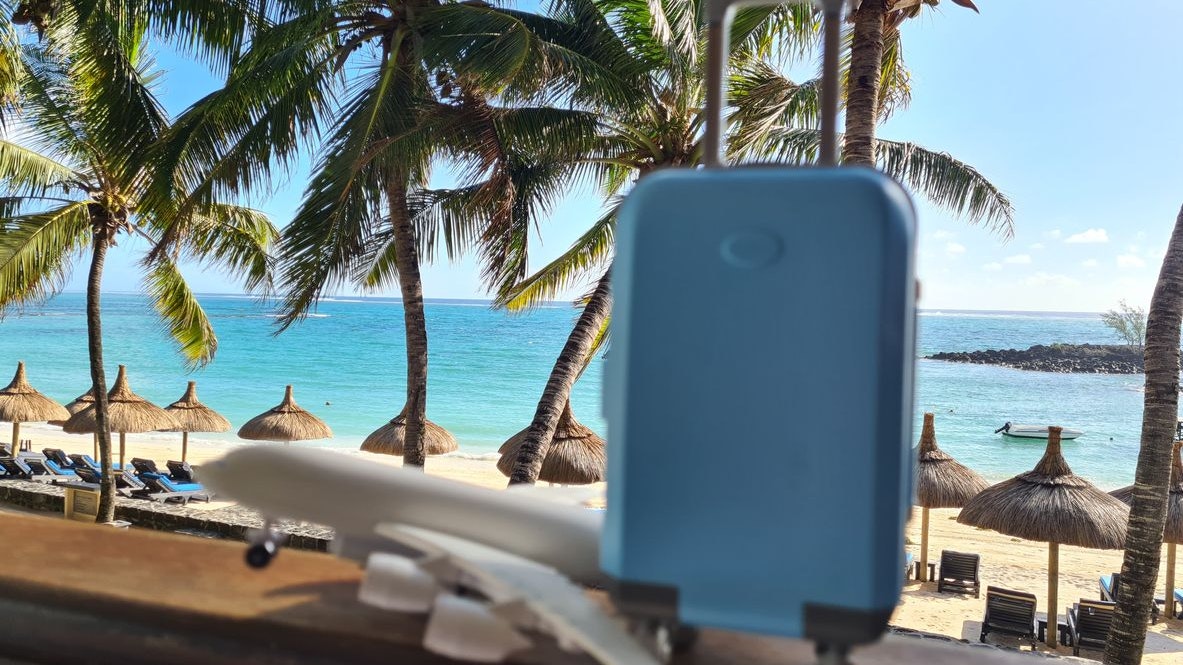 Travel suitcase and plane on background of sea and ocean. Tourist tourism and seaside holidays and air tickets with flights