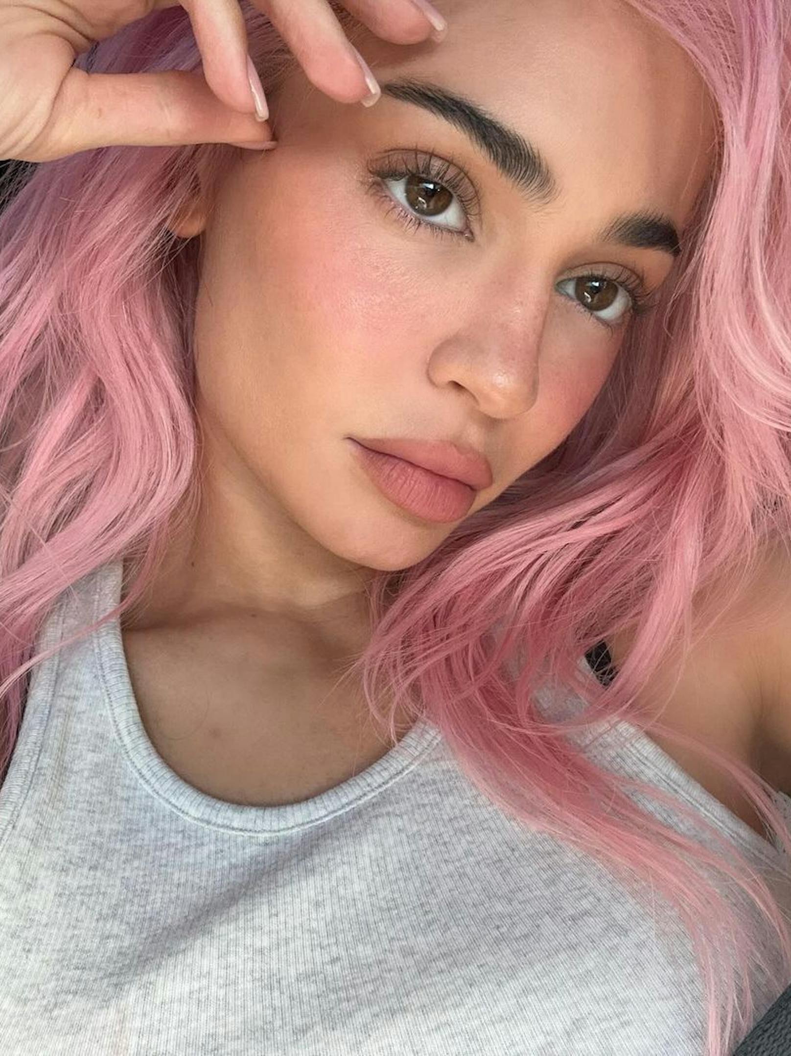 Kylie zeigt ihre pinkfarbene Mähne und unterstreicht ihren Look mit farblich passendem Rouge und Lippenstift.