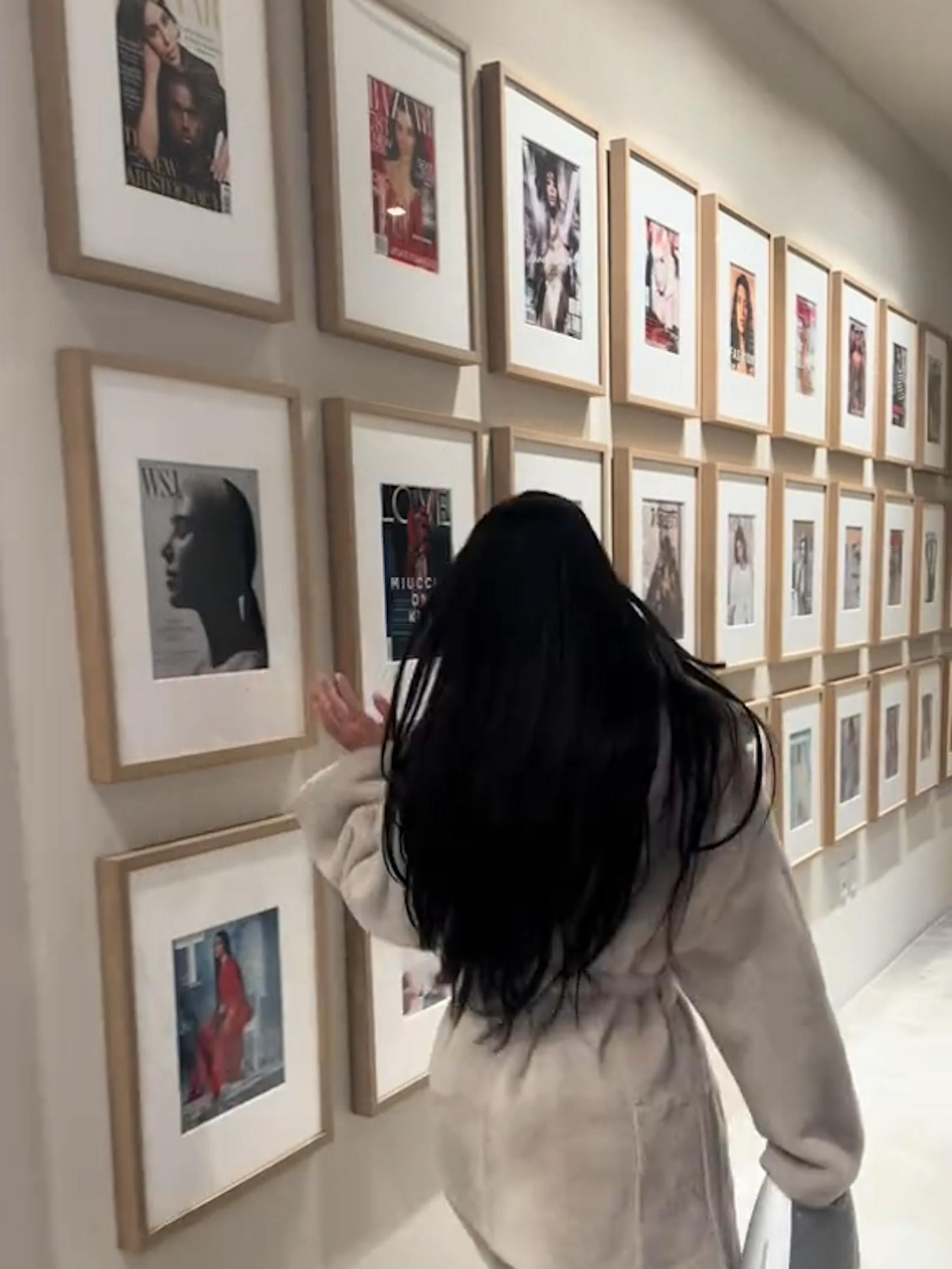 Kim hat eine Wand voller Bilderrahmen mit ihren Titelbildern.