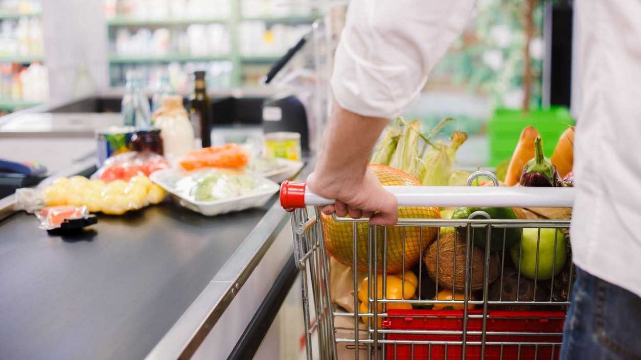 Person buying food products in the supermarket queue