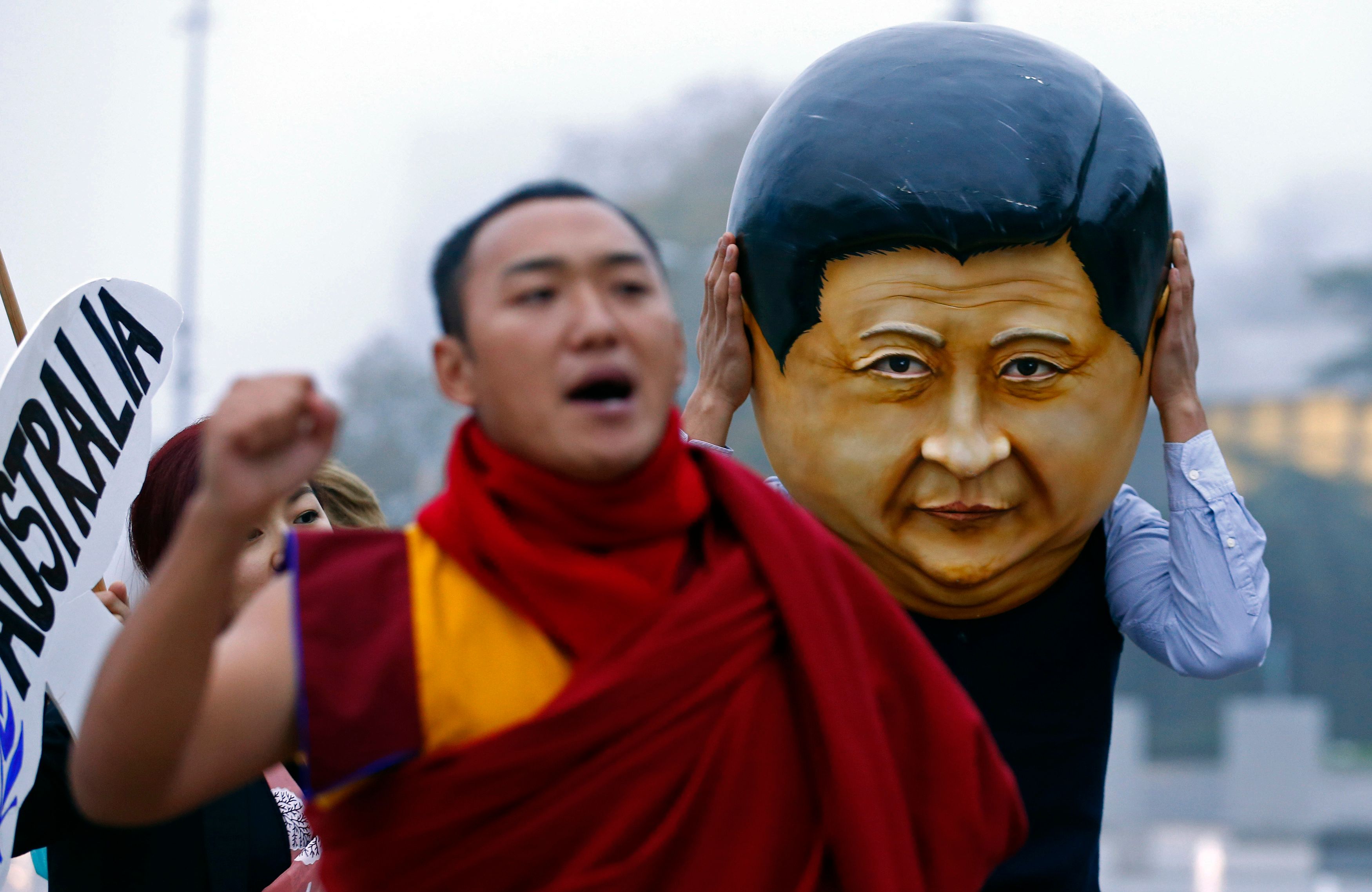 Ein tibetischer Mönch auf einer Demonstration gegen chinesische Menschenrechtsverletzungen in Genf. Hinter ihm läuft ein als Xi Jinping verkleideter Demonstrant-