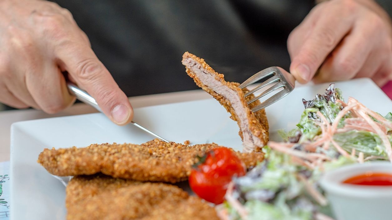 Man Eating Crispy Pork Cutlets