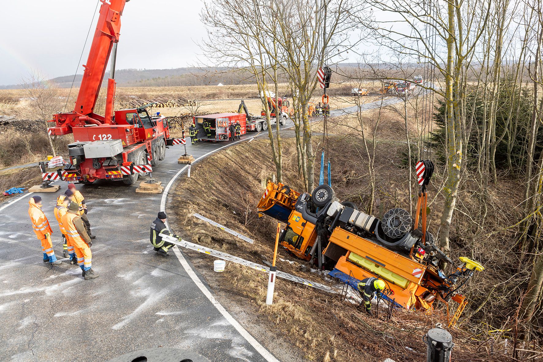 Ein Fahrzeug des Straßendienstes rutschte bei Glatteis von der Straße und landete am Dach.