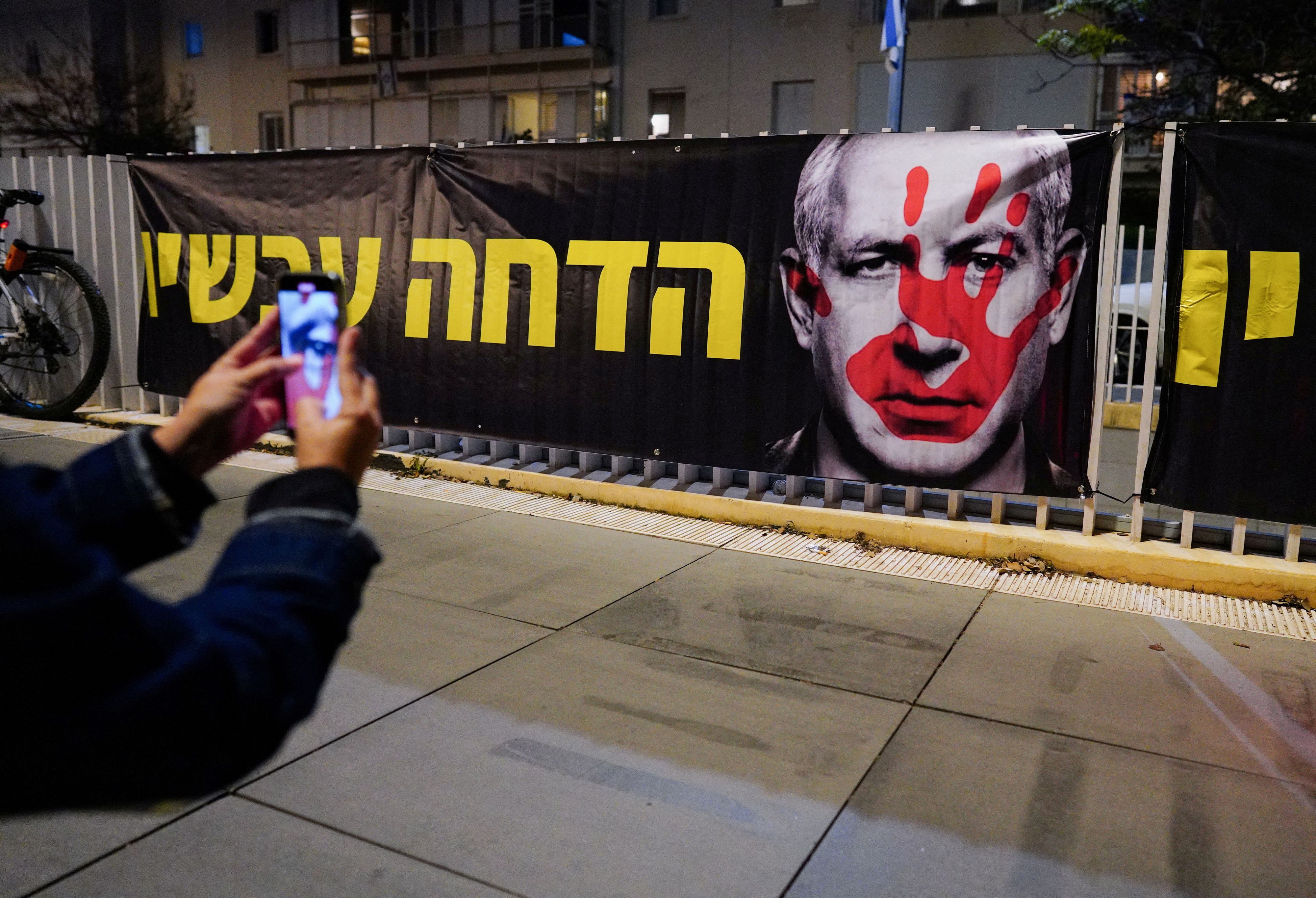 Ein Banner mit dem Gesicht Benjamin Netanjahus und einer blutigen Hand in Tel Aviv.