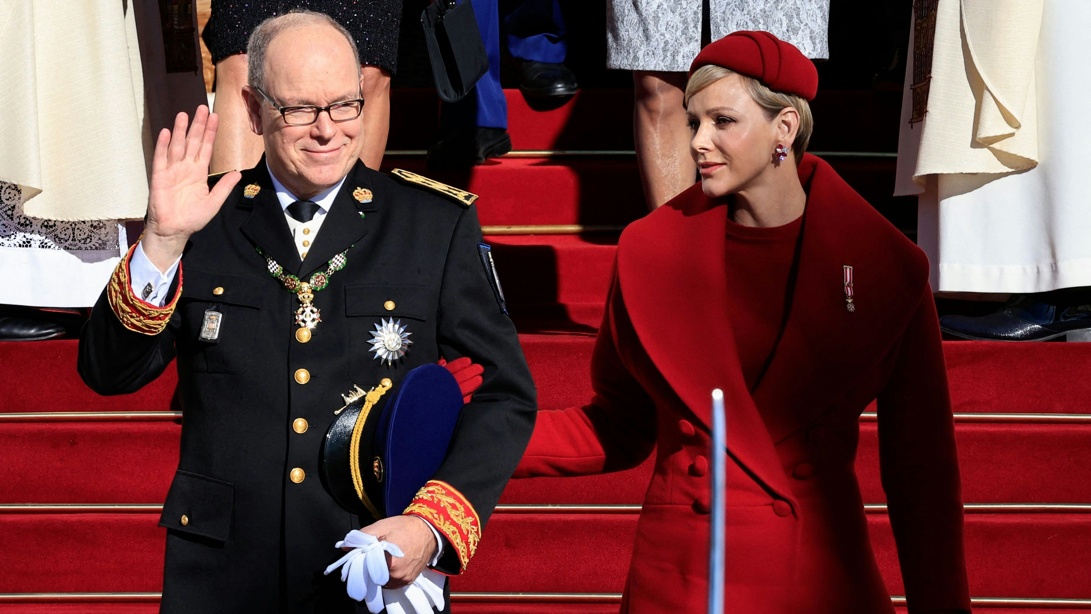 Fürst Albert II. von Monaco (L) winkt, flankiert von Fürstin Charlene von Monaco (R), beim Verlassen der Kathedrale von Monaco nach der Teilnahme an einer Zeremonie zum Nationalfeiertag in Monaco am 19. November 2023.