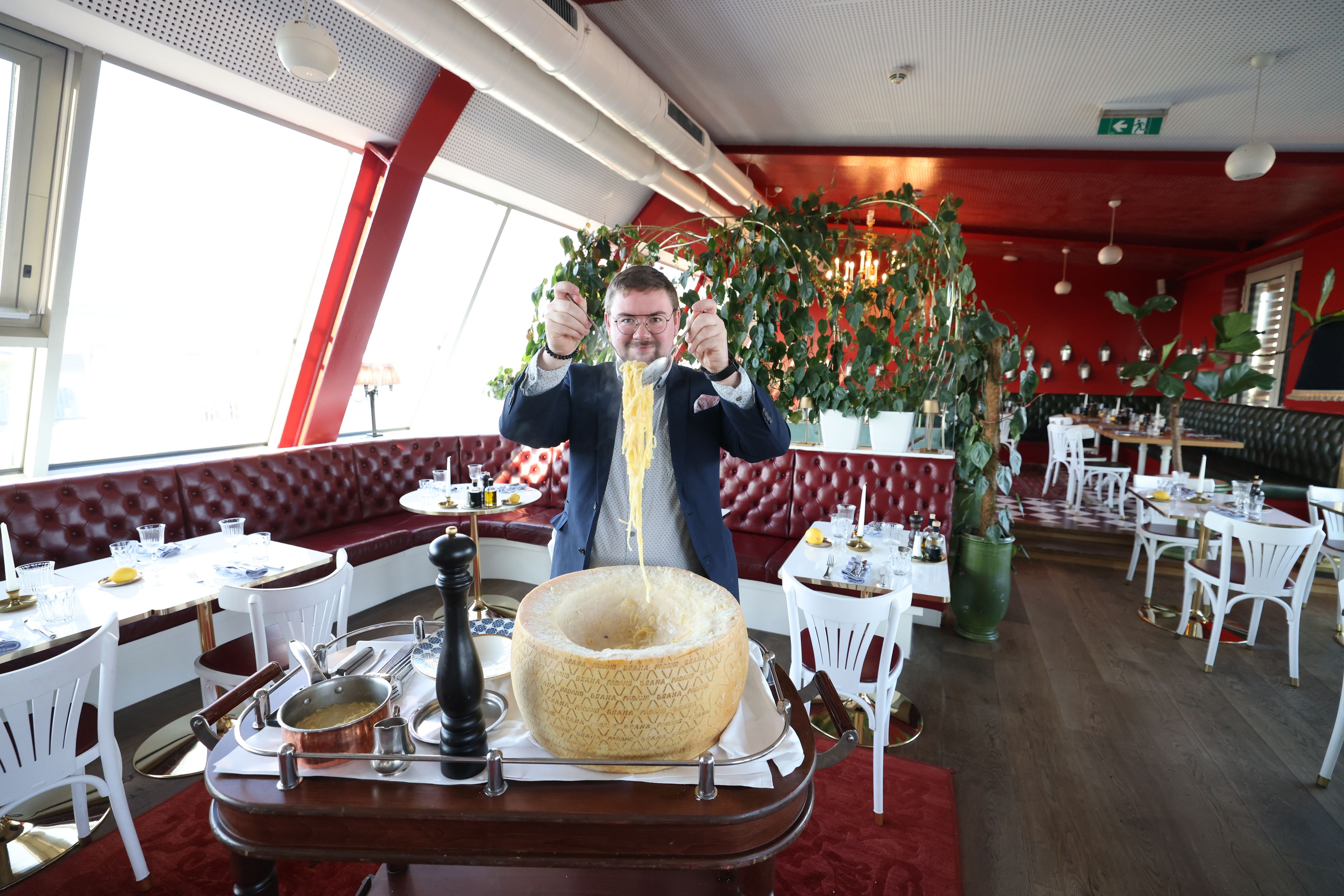 Tim Grunow ist stellvertretender Restaurantleiter im Limón am Schubertring. Hier schwenkt er die Pasta im Parmesanlaib.