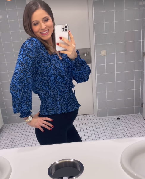 Kristina zeigt stolz ihren Babybauch.