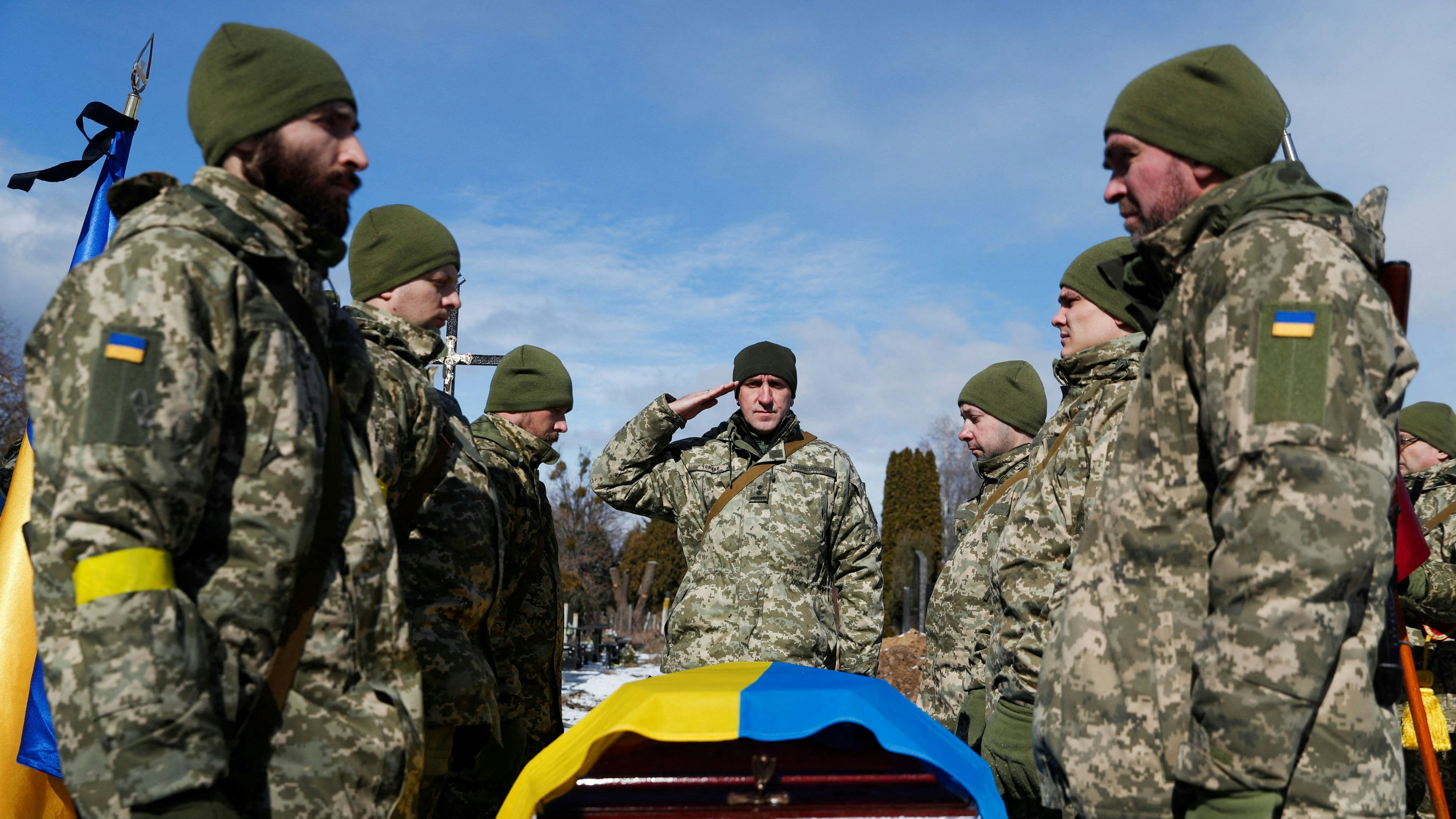 Members of the Honour Guard stand next to a coffin with a body of the member of the Ukrainian Armed Forces, Valerii, who was killed during Russia's invasion of Ukraine, during a funeral ceremony in Kyiv, Ukraine, March 8, 2022.  REUTERS/Valentyn Ogirenko
