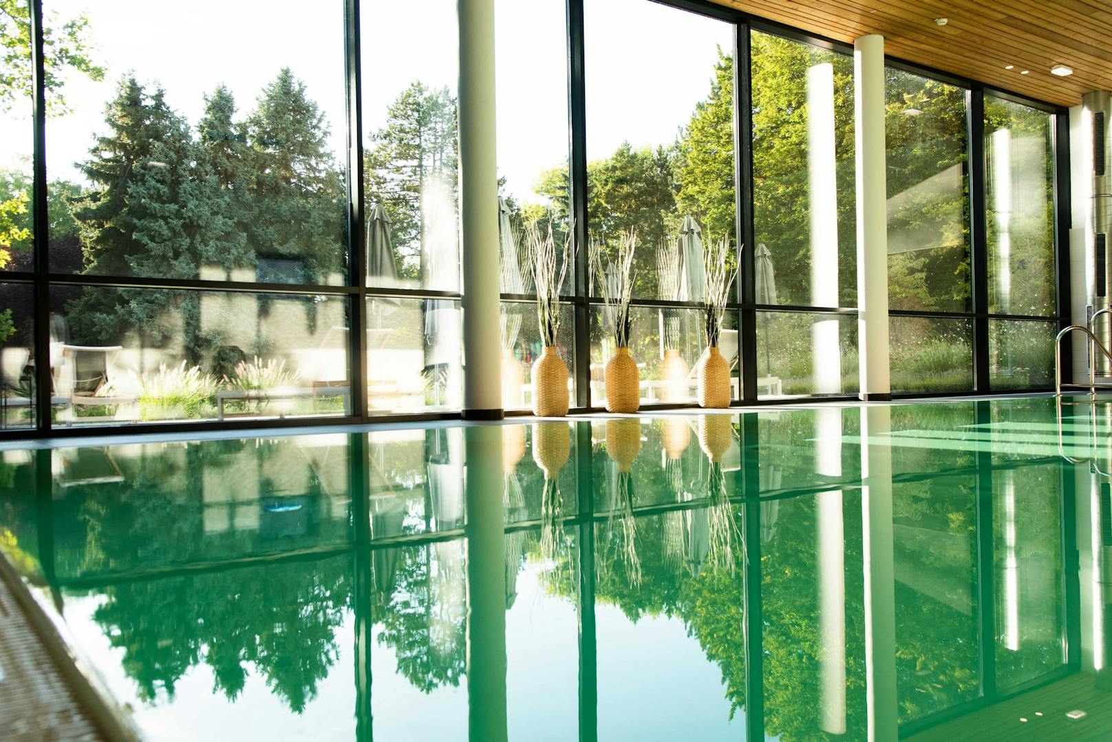 Der Indoor-Pool mit seinem Park-Panorama bietet viel Grün für gestresste Geister.