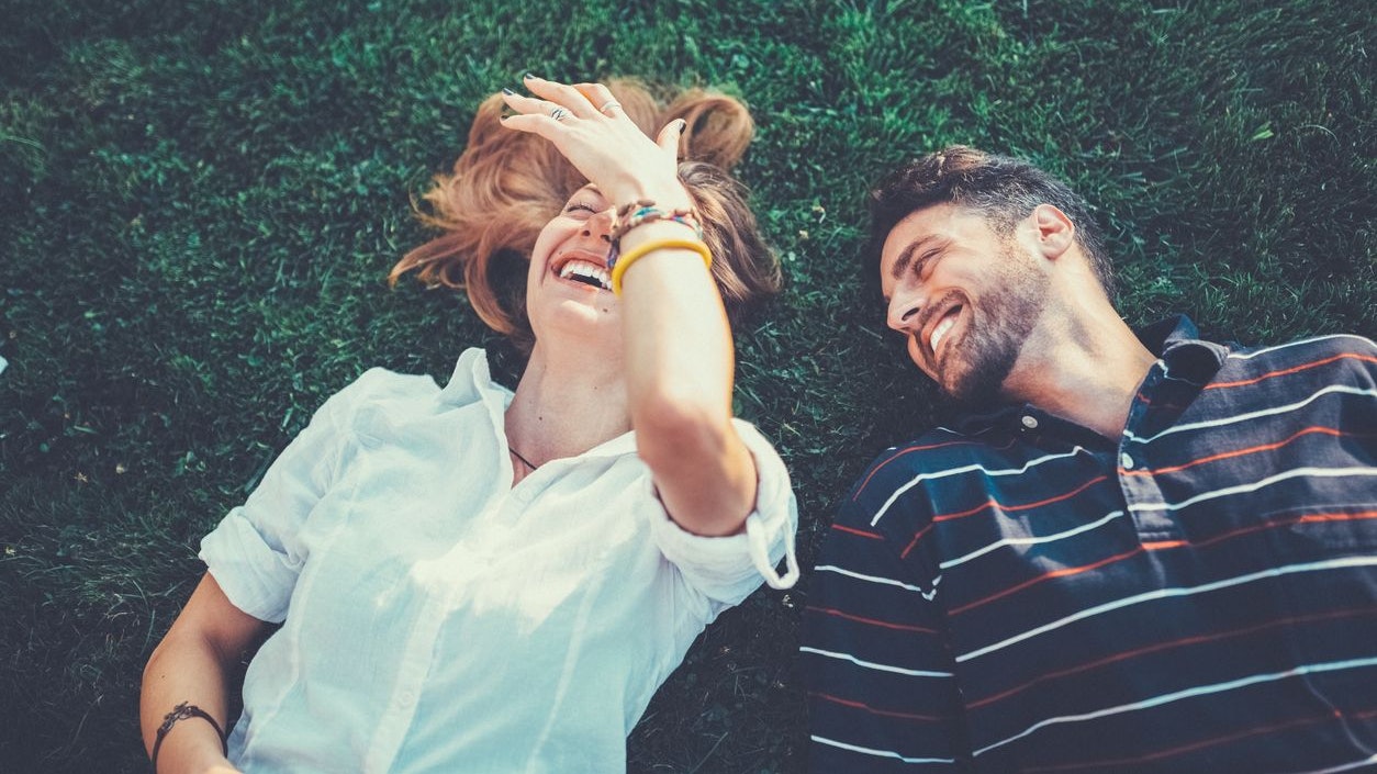 Happy couple in the grass dreaming