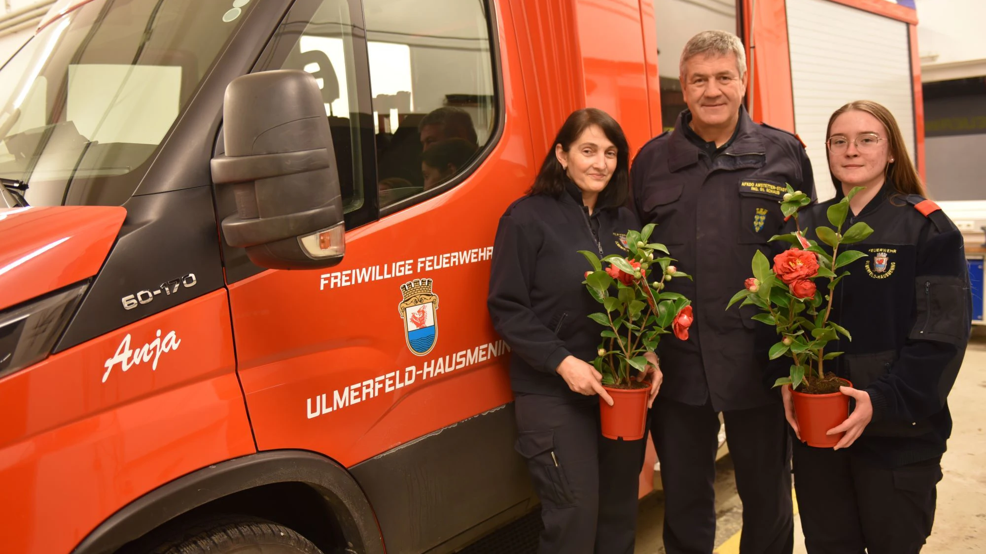 Amstettens Abschnittsfeuerwehrkommandant Stefan Schaub überreicht Elke Grillenberger und Simone Loibl von der Freiwilligen Feuerwehr Ulmerfeld-Hausmening Blumen.