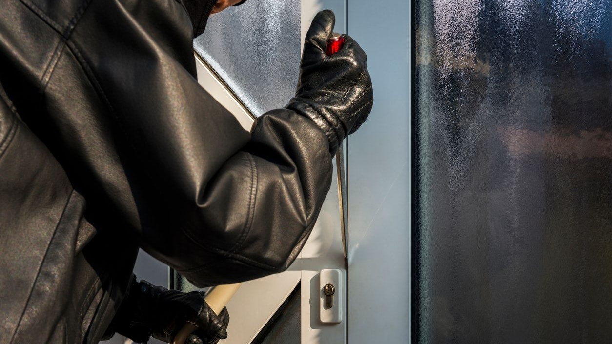 burglar opening front door of a house