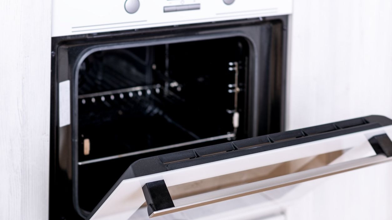 Opened electric oven in white kitchen interior, nobody