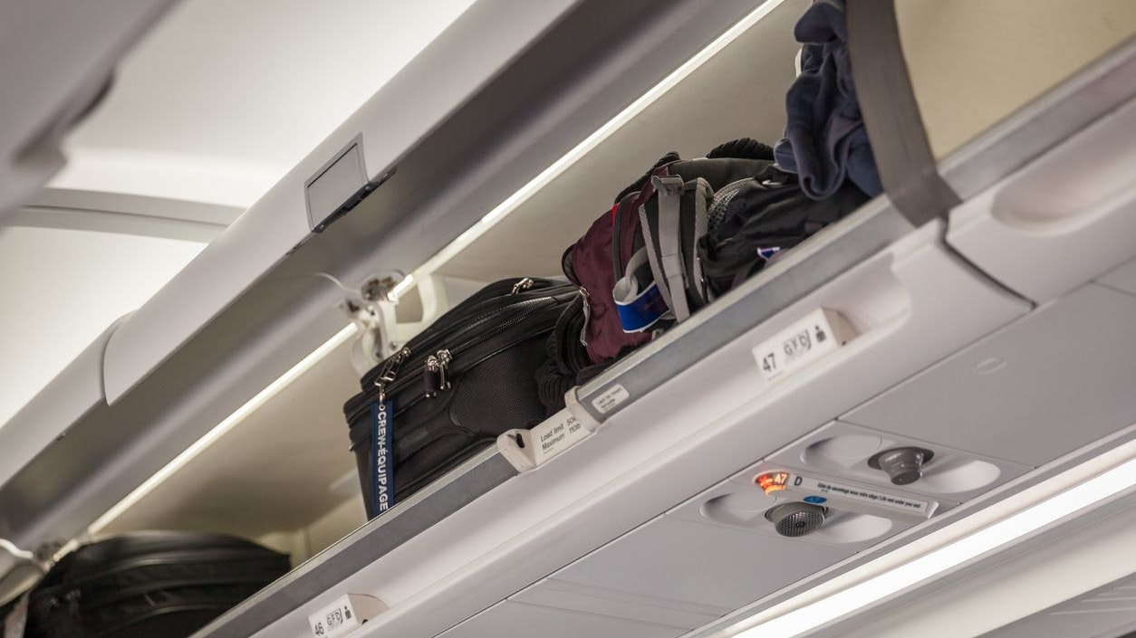 Hand luggage into the compartment on the plane