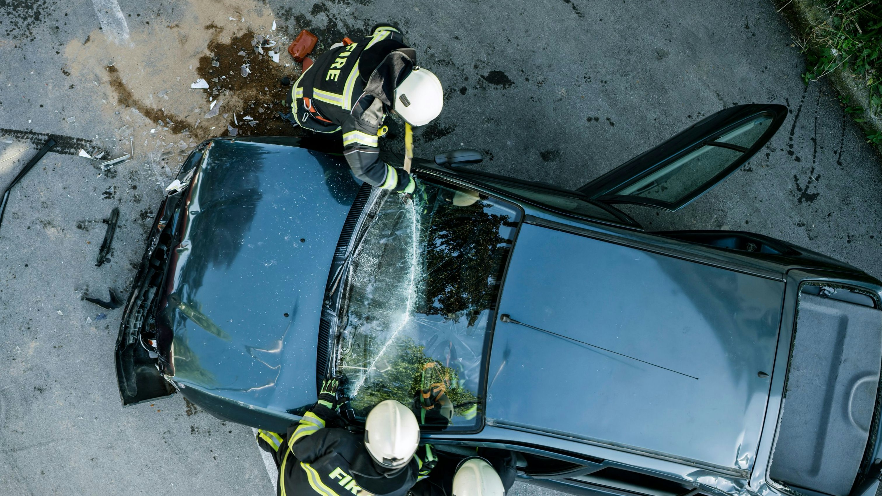Firefighters using a glass cutter to cut car windscreen after accident.