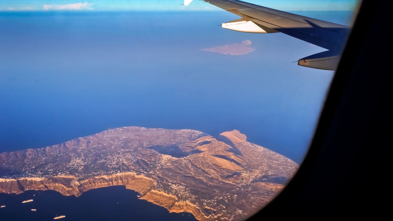Plane wing in the sky over the sea near Crete island Greece