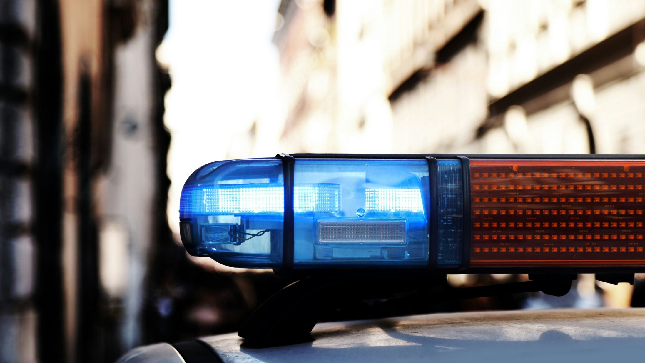 blue lights of a siren of police car during patroling in the city with dark effect