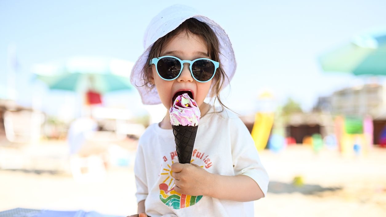 Kleines Kind mit einem Eis am Strand