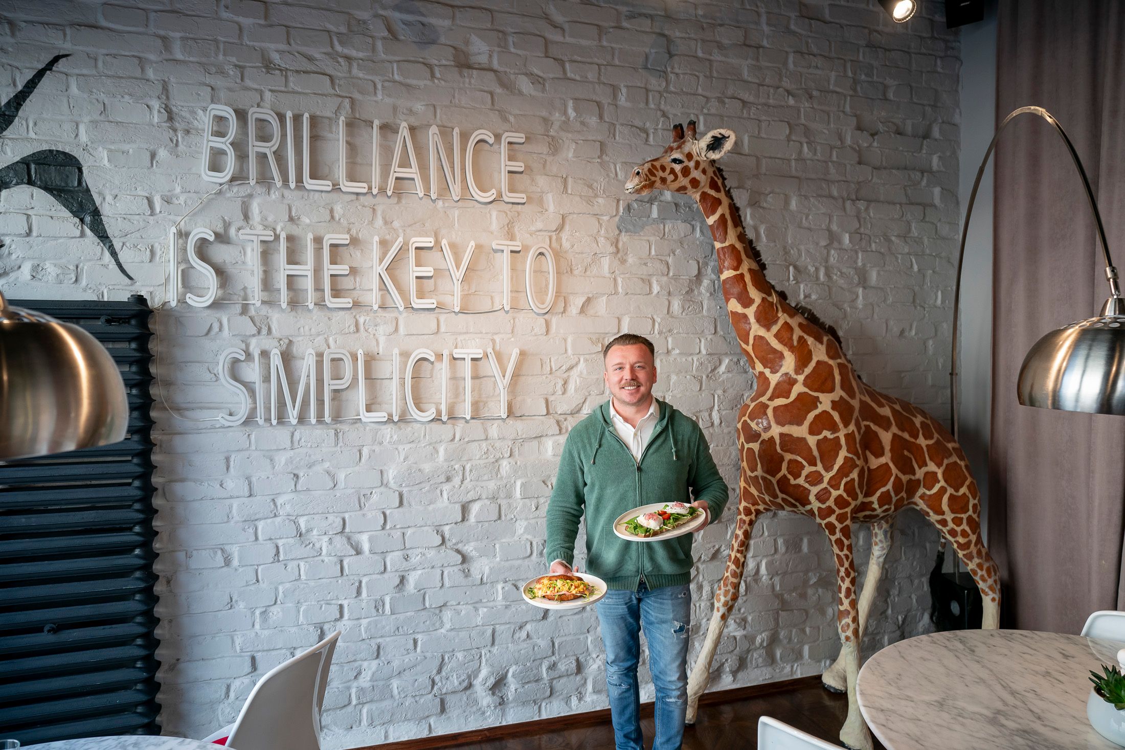 Inhaber Marcel&nbsp;Tunjic vor dem Namensgeber des Lokals, Giraffe Melman.