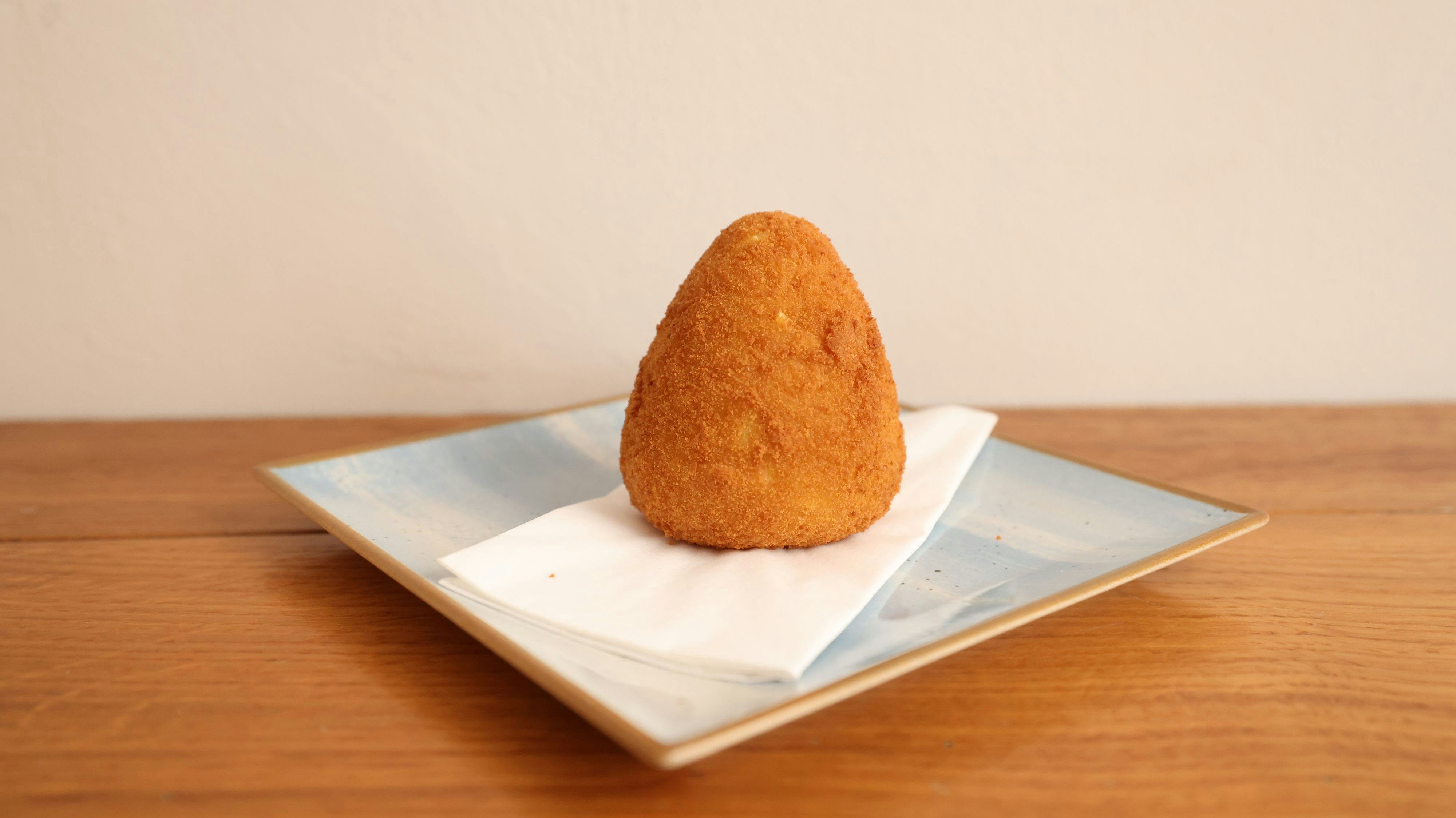 Arancini sind eine Street Food Klassiker aus Sizilien - frittierten Reiskugeln gefüllt mit Hackfleisch, Käse und Tomatensoße