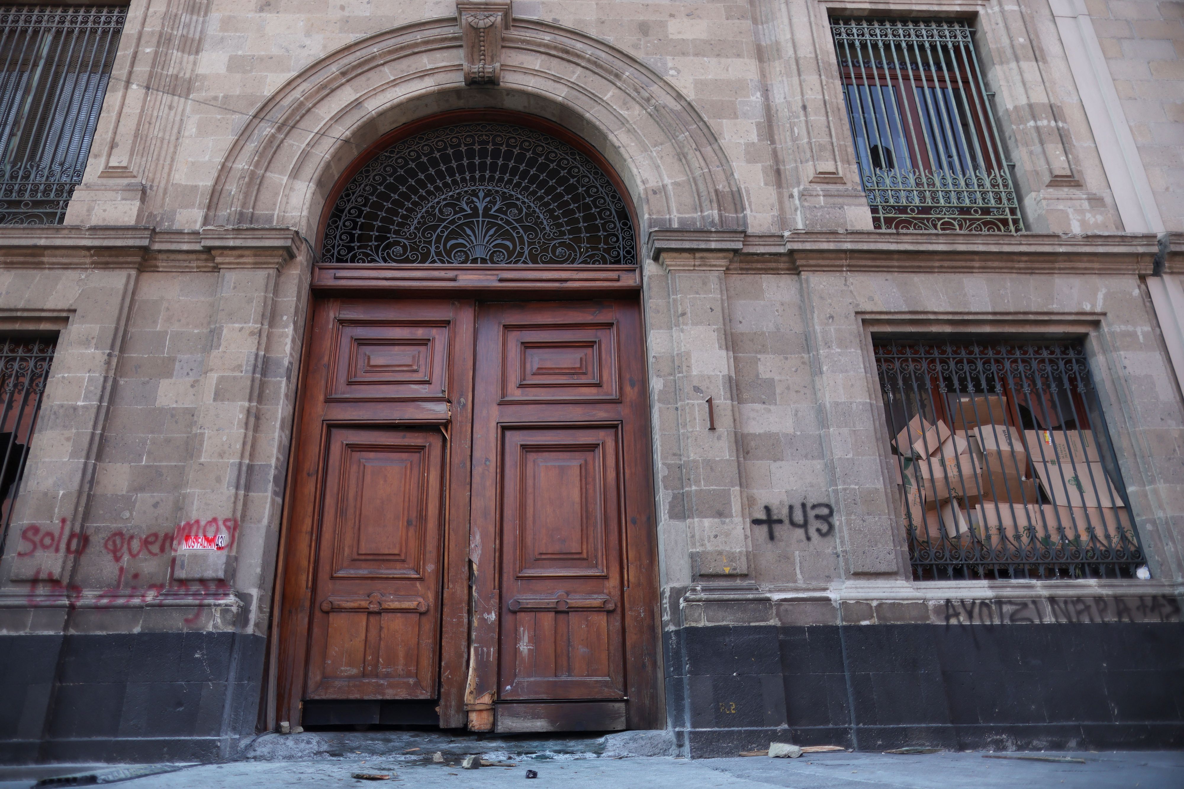Menschen brechen die Türe zum Präsidentenpalast in Mexiko auf.