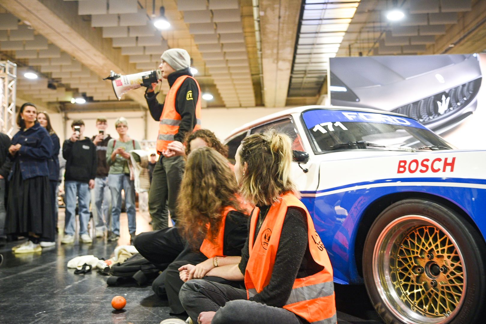 Mit orangen Warnwesten und Bannern kamen vier Personen der Letzten Generation Österreich zur MotionExpo