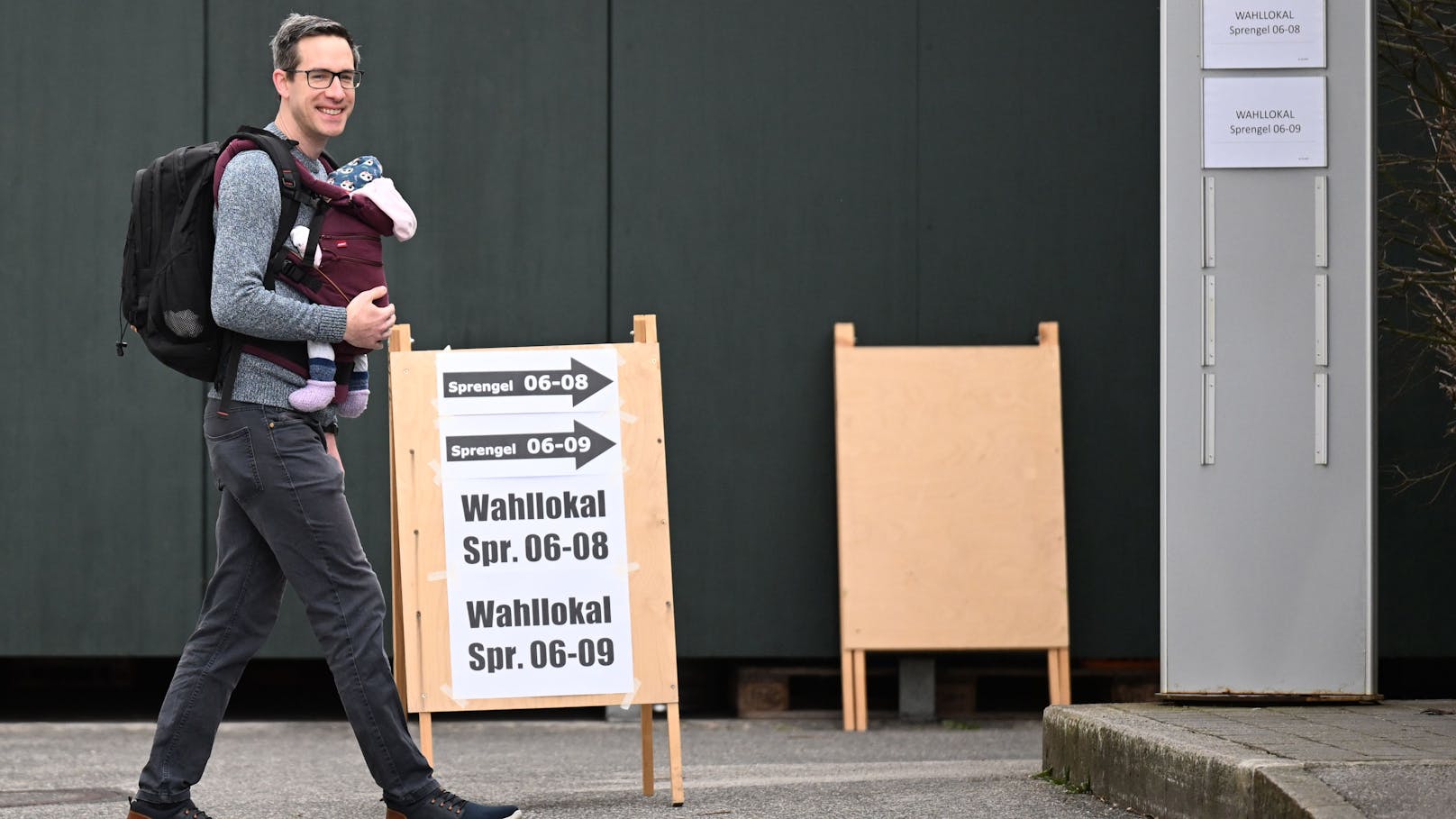Bürgermeisterkandidat der KPÖ Plus, <strong>Kay-Michael Dankl</strong> am Weg zur Stimmabgabe im Wahllokal im Heffterhof in Salzburg-Parsch. Seine im Dezember geborene Tochter hat er im Baby-Tragetuch mitgebracht.
