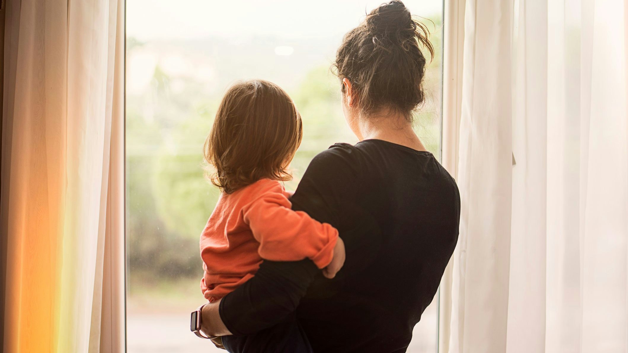 Mutter mit Kind im Arm von hinten