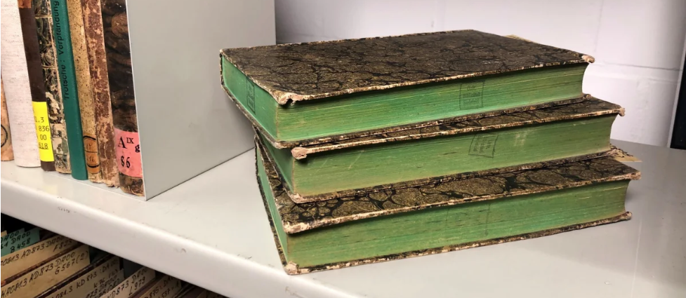 Bücher mit grünem Buchschnitt, die in der Uni-Bibliothek Bielefeld (Deutschland) auf ihre Arsenbelastung getestet werden