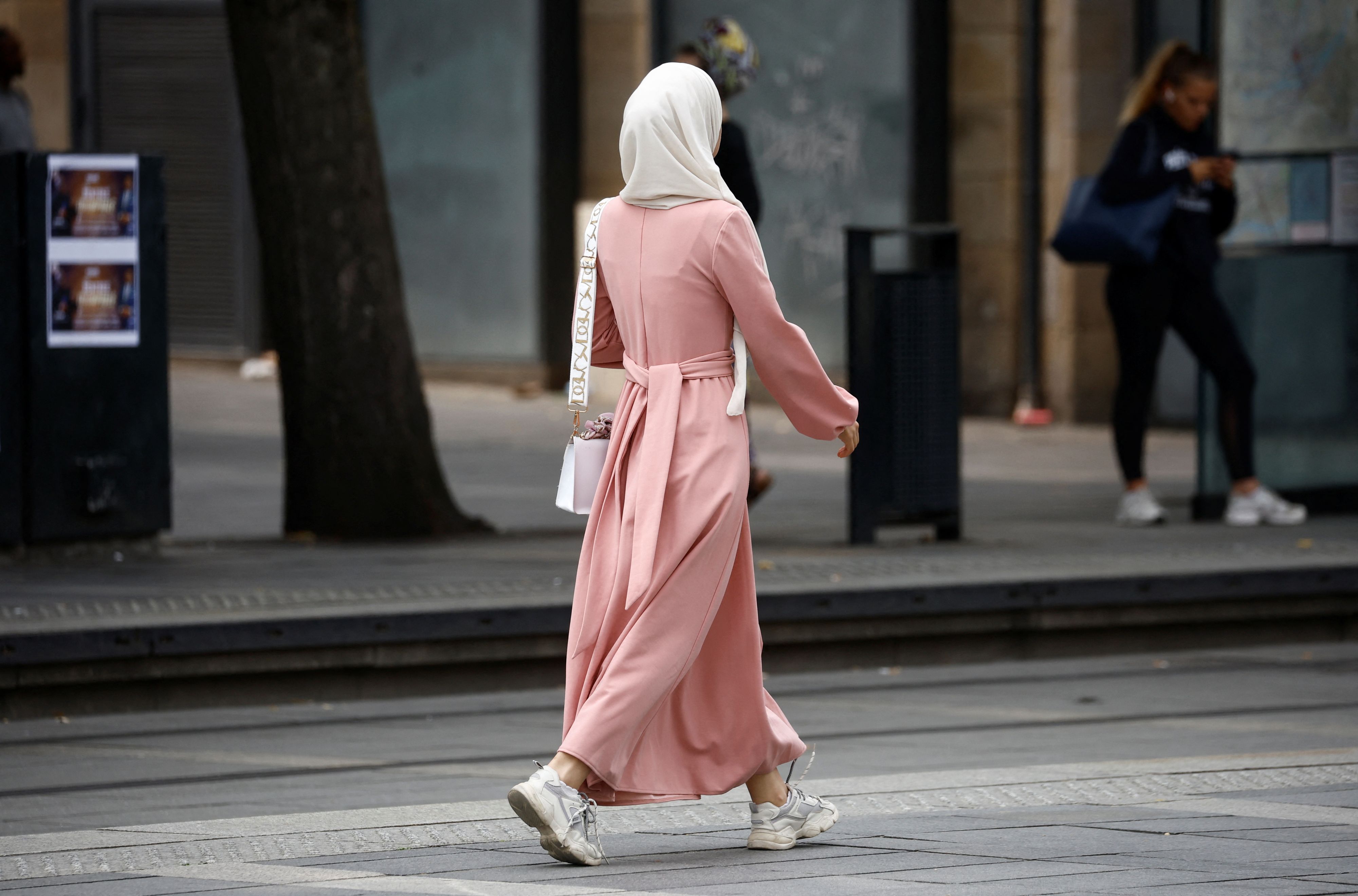 A Muslim woman, wearing the style of dress called an abaya, walks in a street in Nantes, France, August 29, 2023. REUTERS/Stephane Mahe