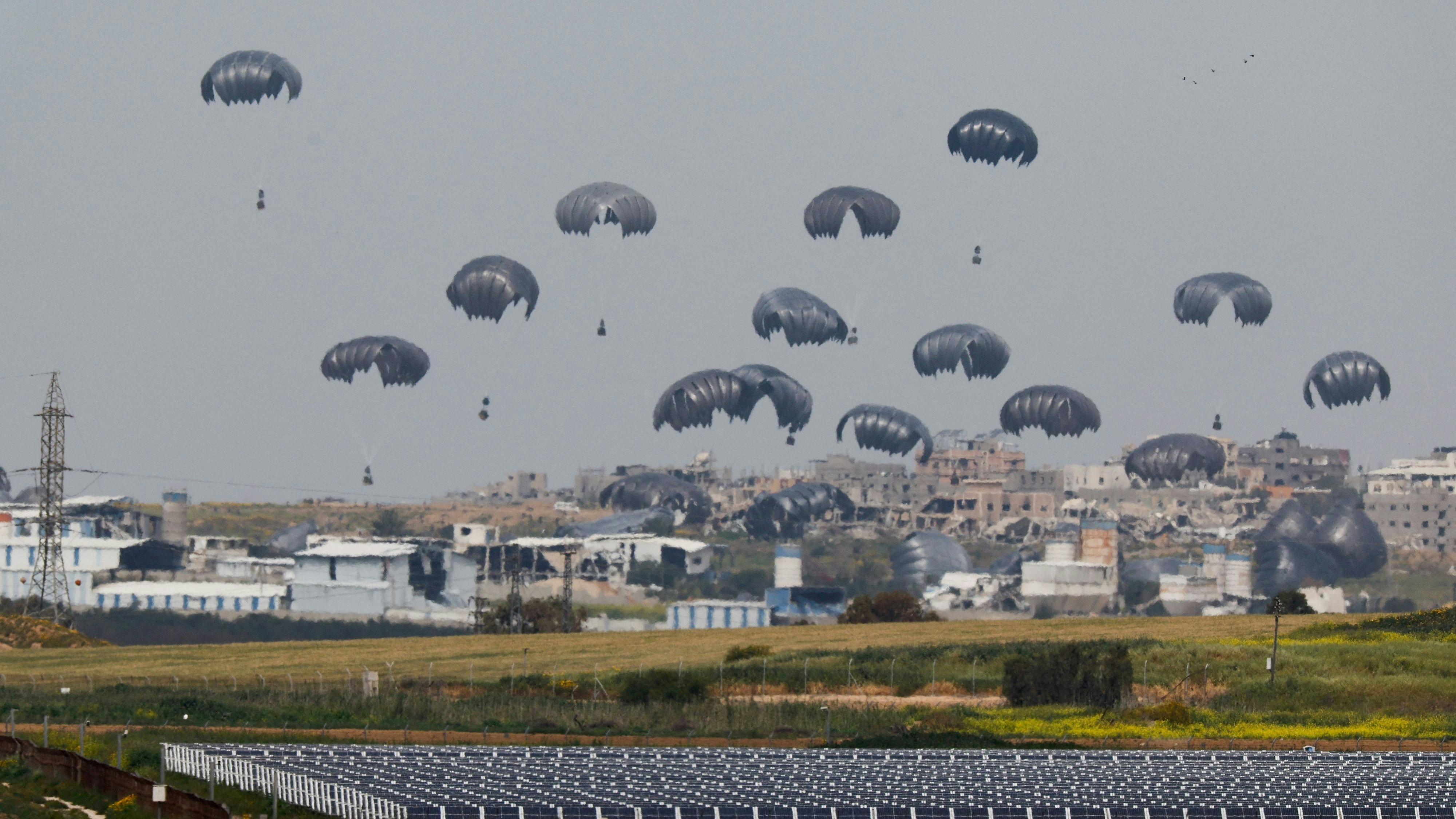 Humanitarian aid falls through the sky towards the Gaza Strip after being dropped from an aircraft, amid the ongoing conflict between Israel and the Palestinian Islamist group Hamas, as seen from Israel's border with Gaza, in southern Israel, March 17, 2024. REUTERS/Amir Cohen     TPX IMAGES OF THE DAY     