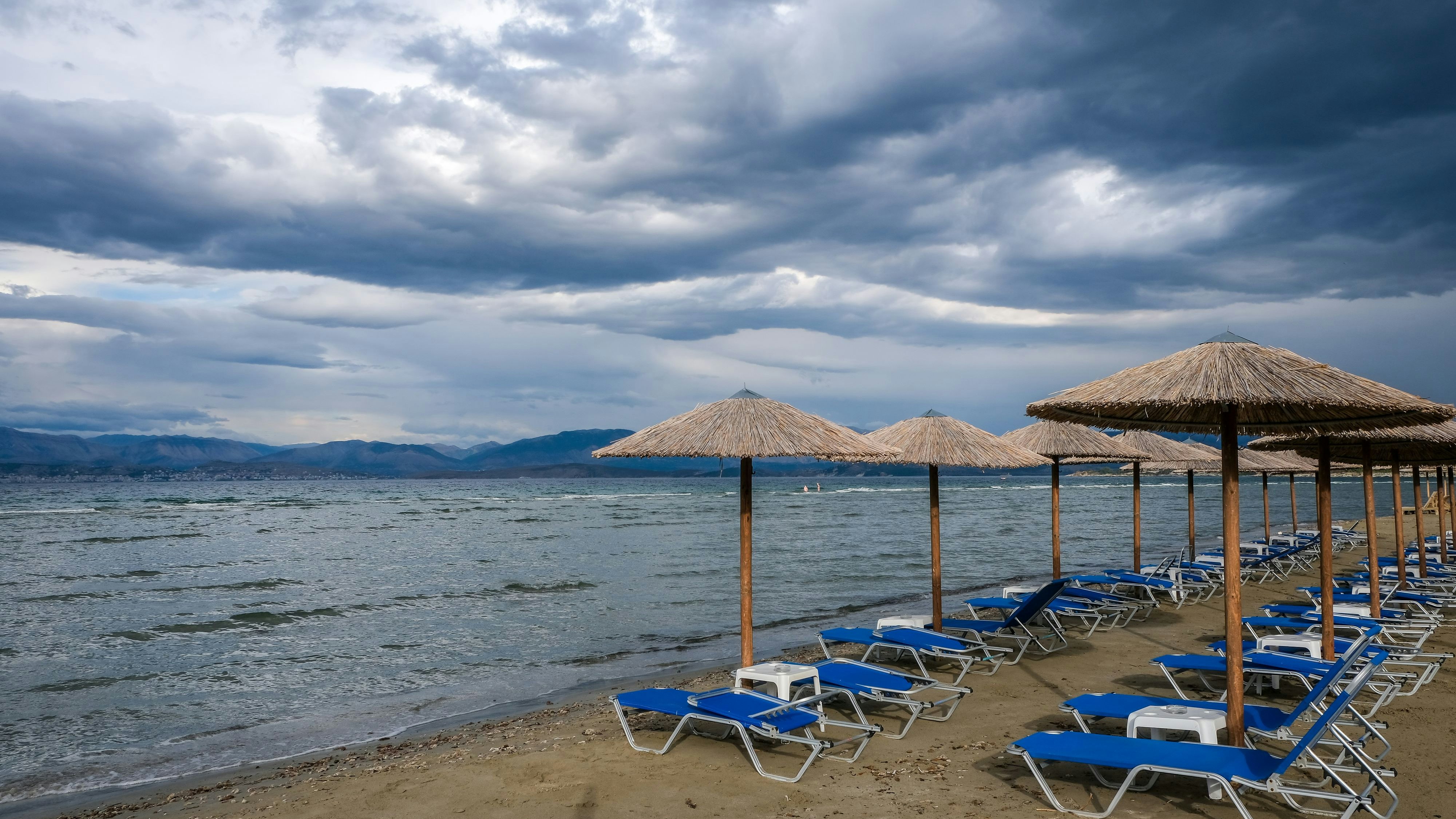 Download von www.picturedesk.com am 19.03.2024 (10:39).  05.09.2023, Kalamaki, Korfu, Griechenland - Sonnenliegen und Sonnenschirme am Kalamaki Strand im Nordosten der griechischen Insel Korfu. Hinten Festland Albanien mit dem Badeort Saranda. 00X230905D032CARO [MODEL RELEASE: NO, PROPERTY RELEASE: NO (c) caro images / Rupert Oberhaeuser - 20230905_PD18523 - Rechteinfo: Rights Managed (RM)