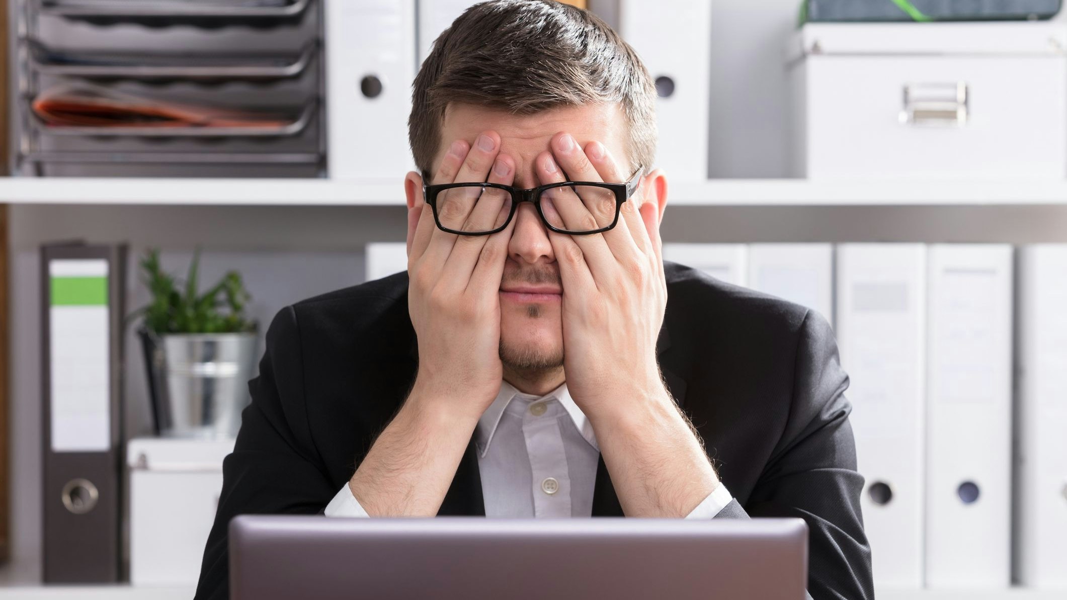 Close-up Of A Tired Young Businessman Sitting In Office