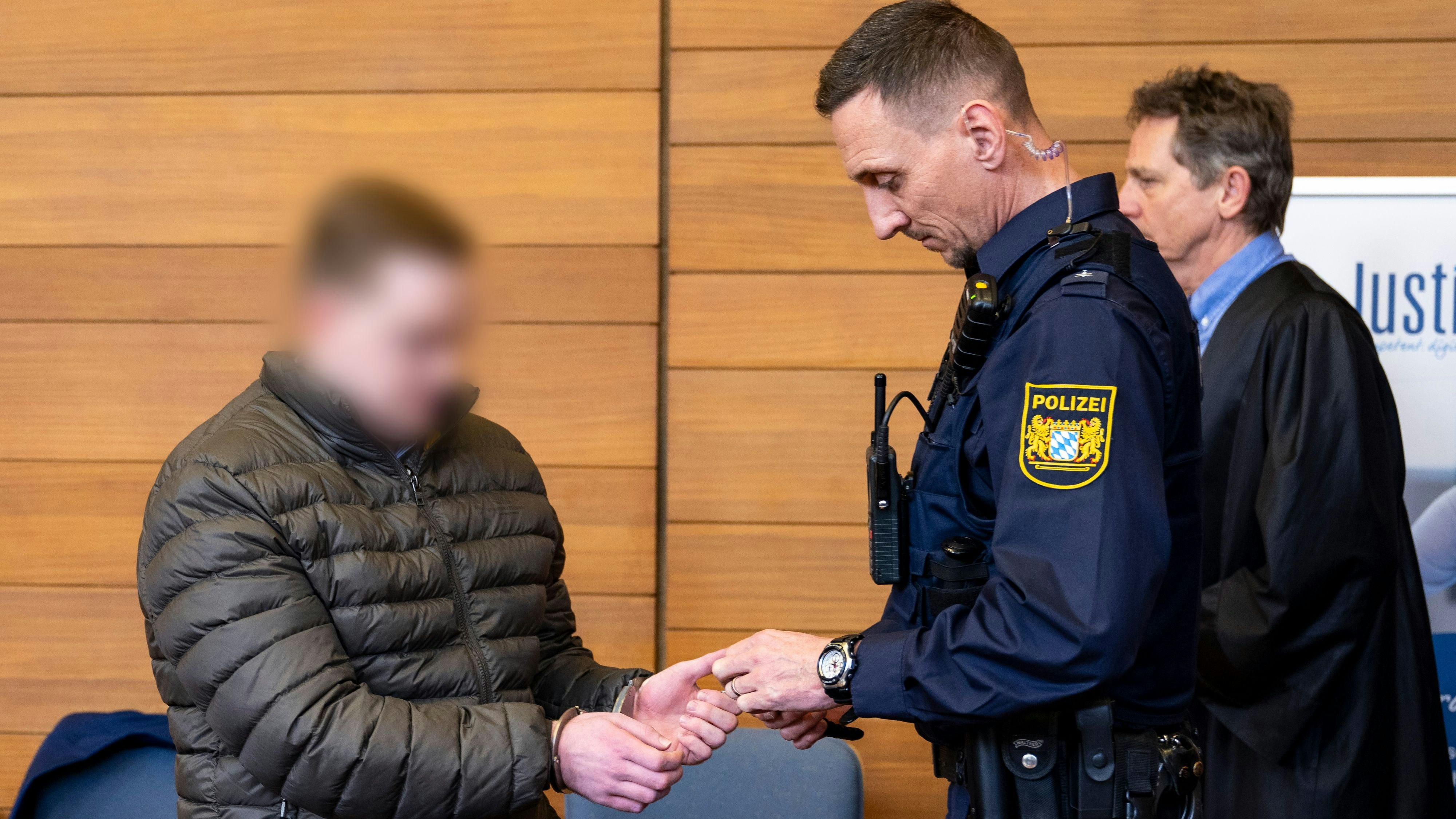 Download von www.picturedesk.com am 19.03.2024 (13:16).  19 March 2024, Bavaria, Traunstein: The defendant (left) in the trial for the death of student Hanna is brought into the courtroom of the Traunstein district court by a police officer. On Tuesday, the Traunstein district court sentenced a 22-year-old to nine years' juvenile detention for the murder of student Hanna. Photo: Lennart Preiss/dpa - ATTENTION: Person(s) has/have been pixelated for legal reasons - 20240319_PD2924 - Rechteinfo: Rights Managed (RM)