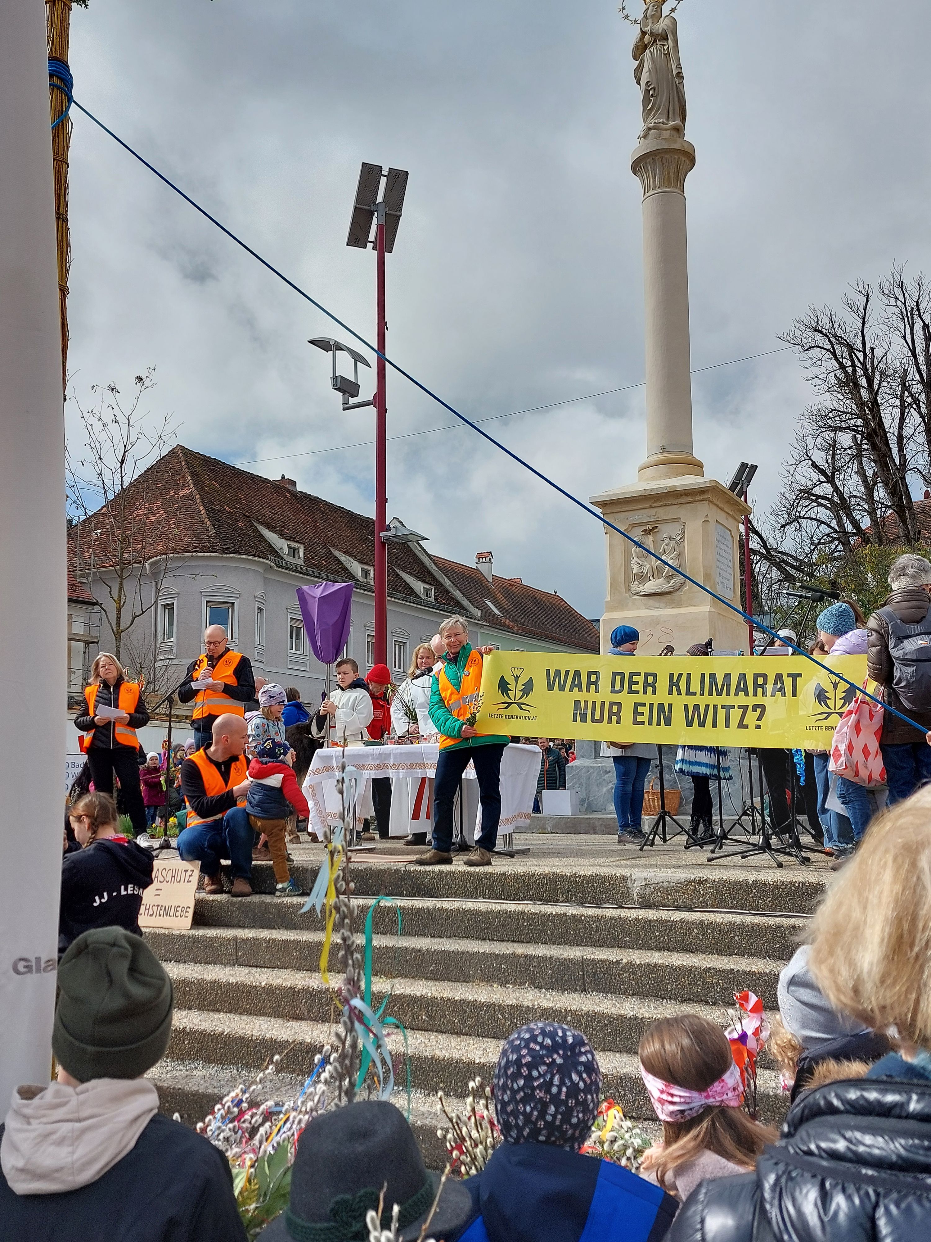 Protestaktion von Klima-Aktivisten der Letzten Generation bei traditioneller Palmweihe am Weizer Hauptplatz am Palmsonntag, 24. März 2024.