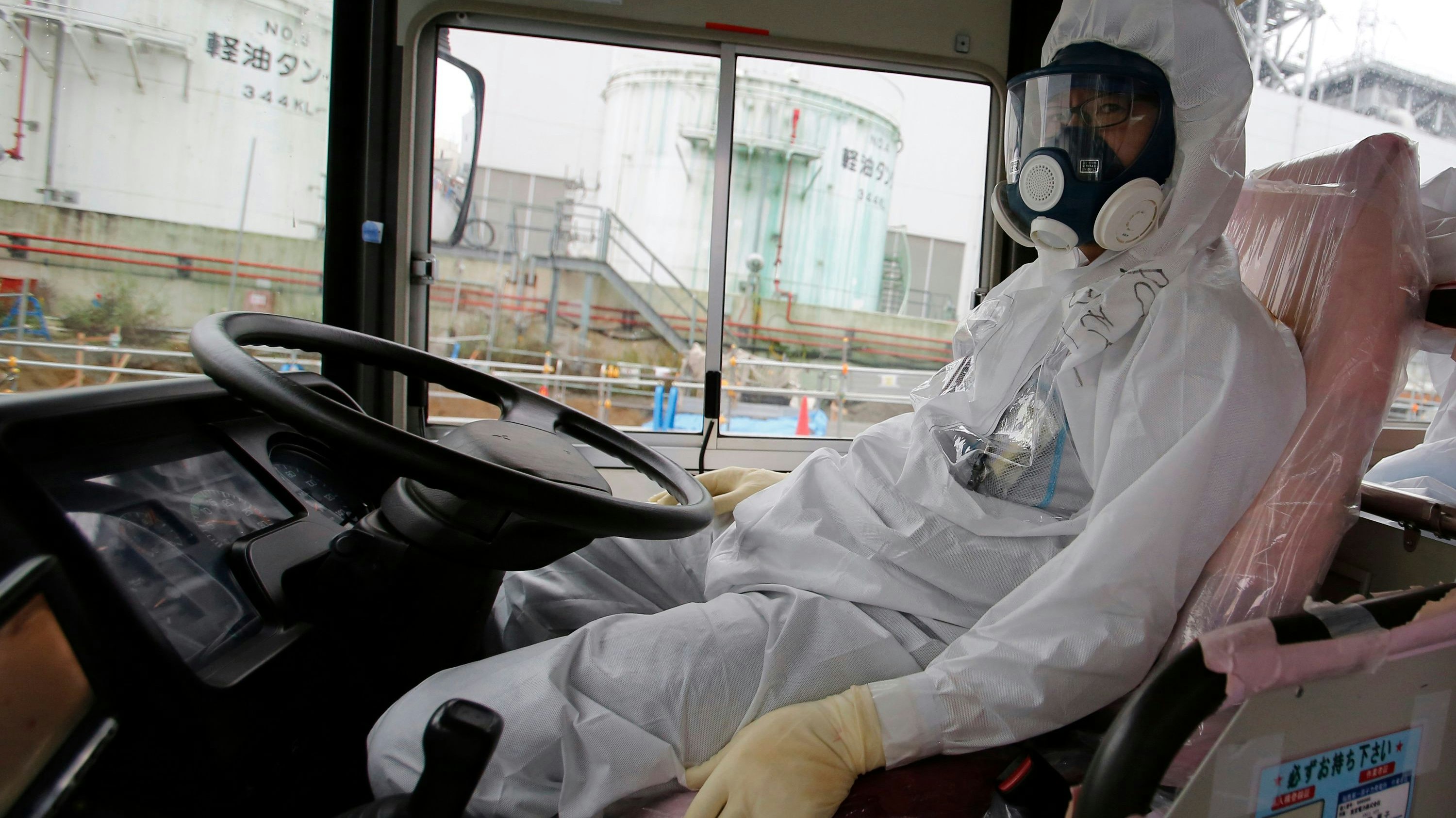 Ein Busfahrer im Schutzanzug während einer Besichtigungstour für Journalisten im Atomkraftwerk Fukushima Daiichi