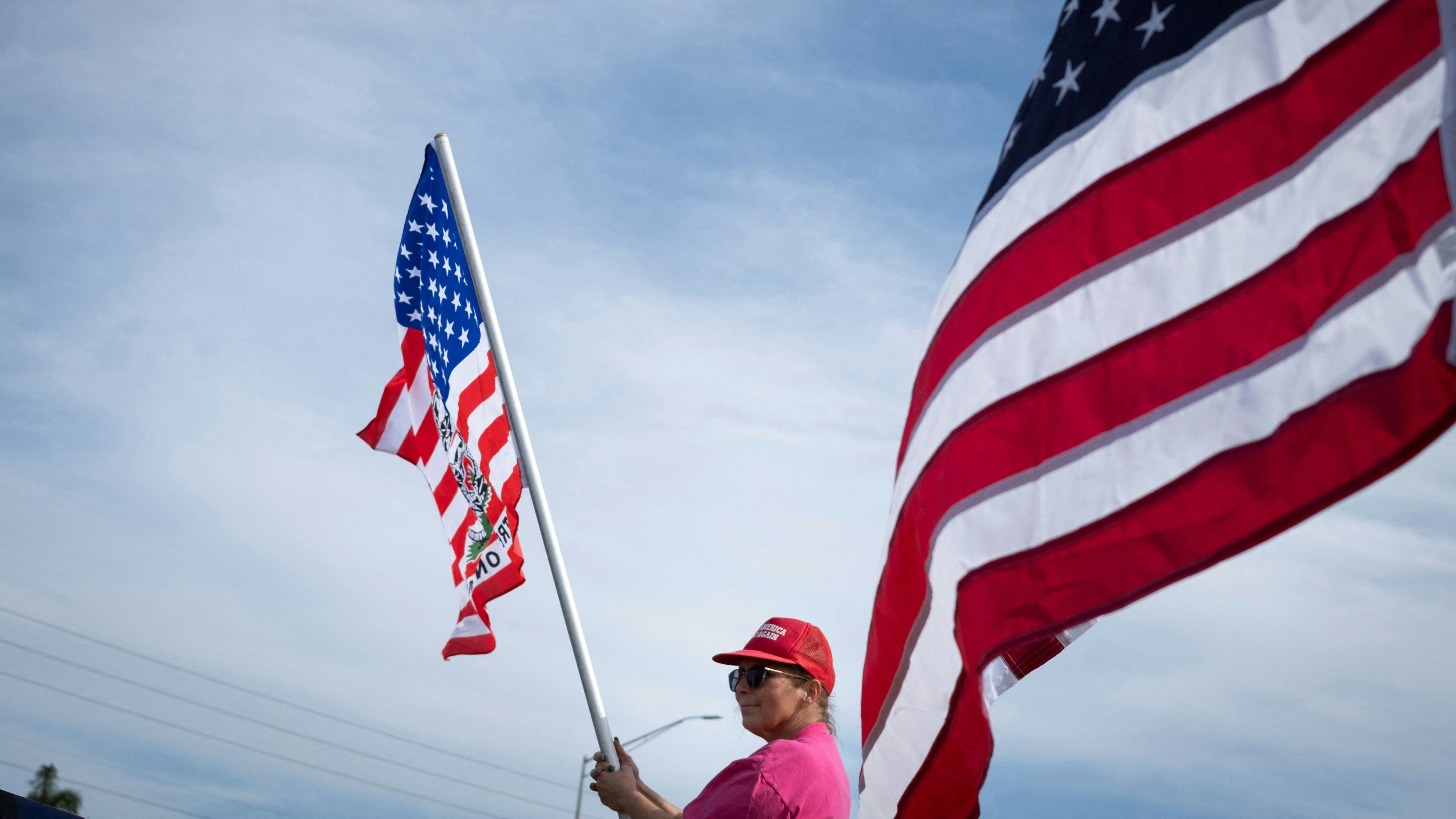 A supporter of Republican presidential candidate and former U.S. President Donald Trump waves a flag during a gathering in Palm Harbor, Florida, U.S. March 10, 2024. REUTERS/Marco Bello