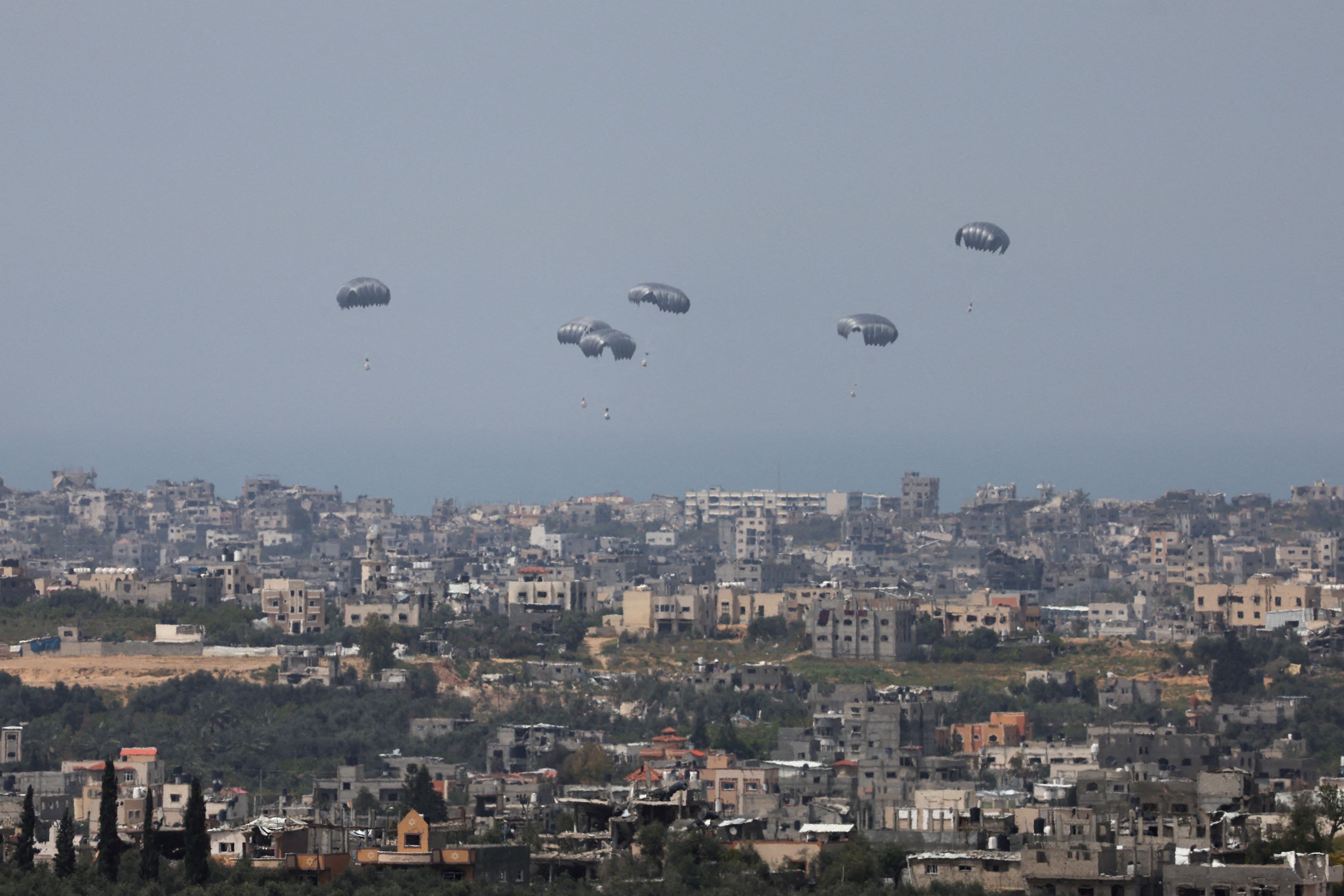 Humanitarian aid falls through the sky towards the Gaza Strip after being dropped from an aircraft, amid the ongoing conflict between Israel and the Palestinian Islamist group Hamas, as seen from Israel, March 27, 2024. REUTERS/Ronen Zvulun     TPX IMAGES OF THE DAY     