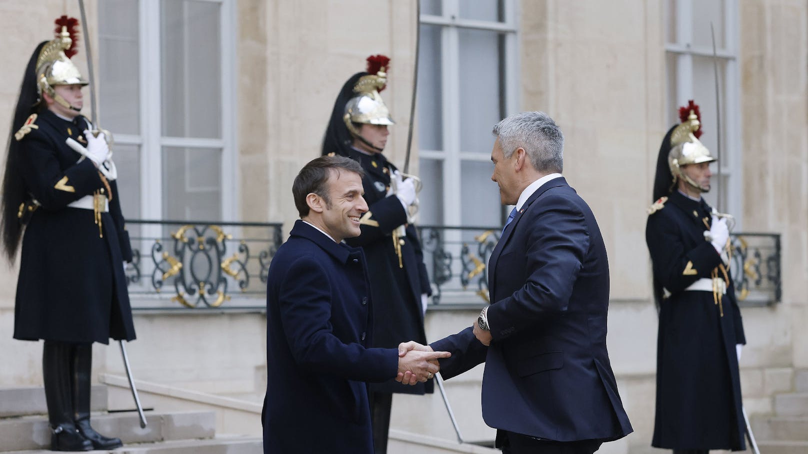 Nehammer und Macron beim Ukrainegipfel in Paris am 26. Februar 2024 – Macron berührt beim Händedruck mit seinem Zeigefinger Nehammers Handgelenk.