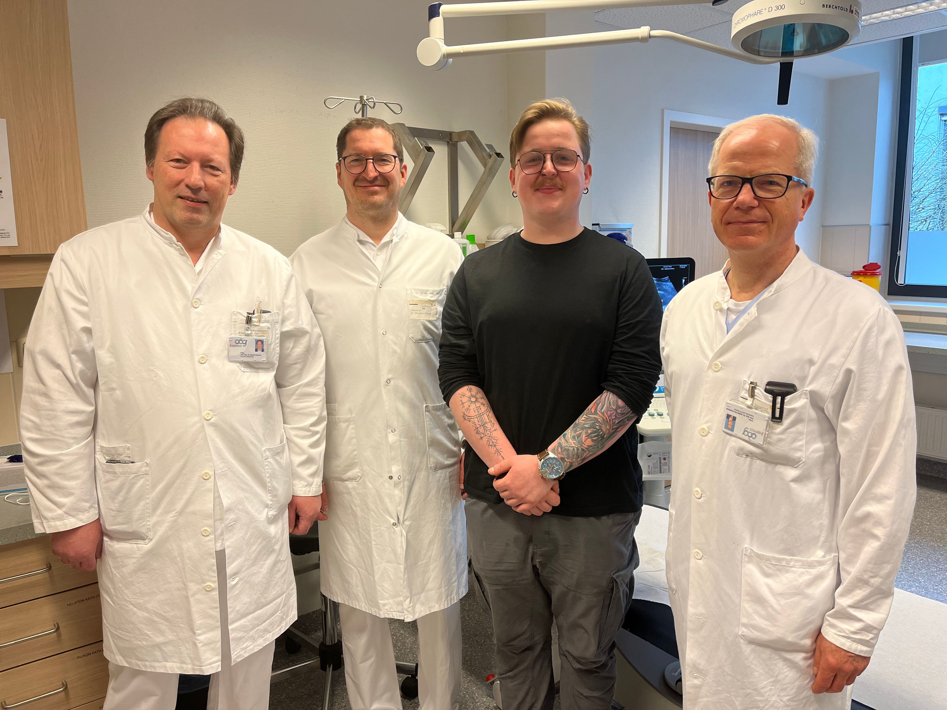 Der 21-jährige Sportler (im Bild mit den behandelnden Ärzten) kann mittlerweile wieder lächeln.