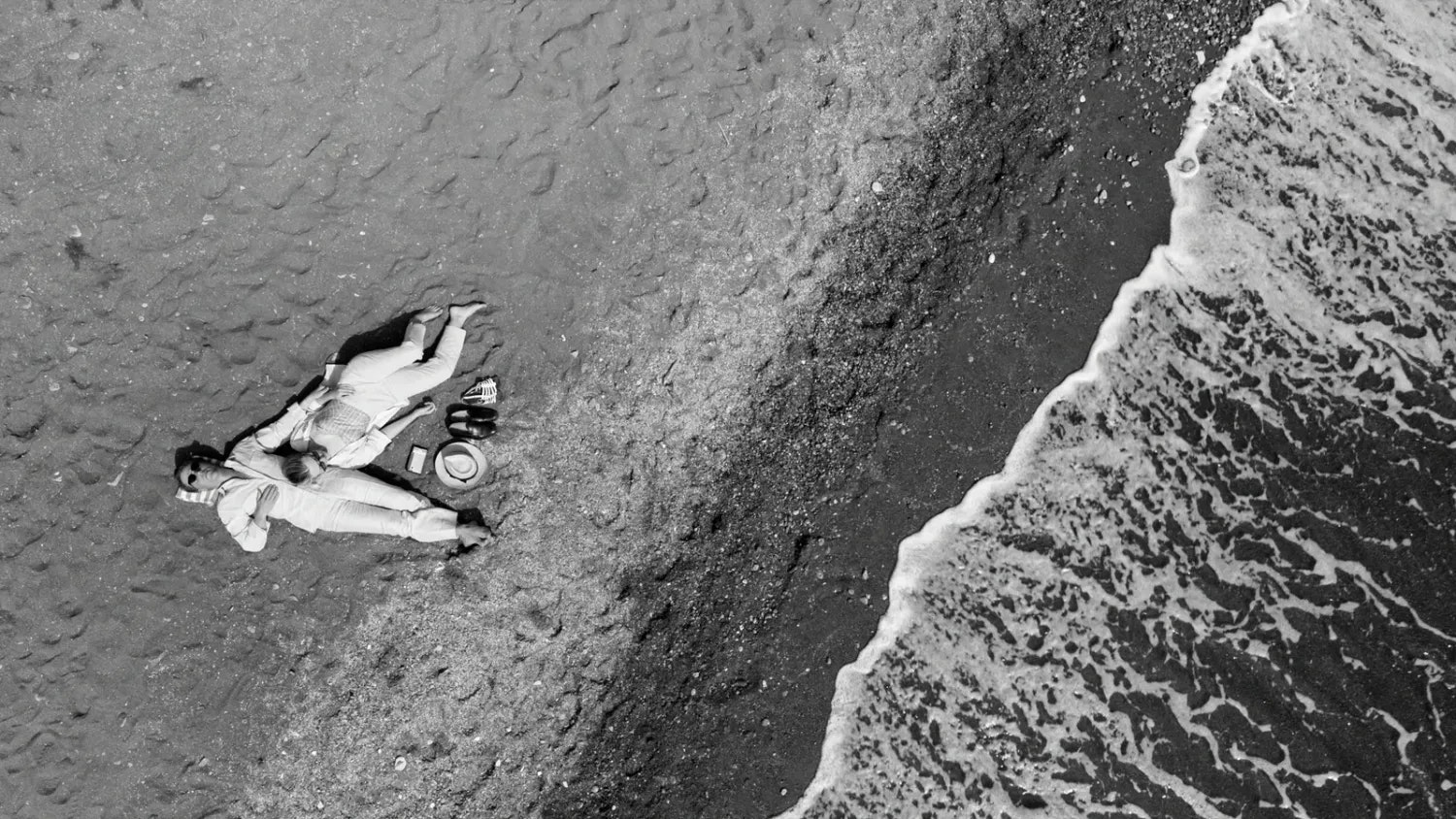 Wie lässt man eine maximal idyllische Szene bedrohlich wirken? Das Liebespaar Dickie (Johnny Flynn) und Marge (Dakota Fanning) am Strand von Atrani an der Amalfiküste. Doch das tiefschwarze Wasser greift bedrohlich nach den beiden, wie der Vorbote eines drohenden Unheils.