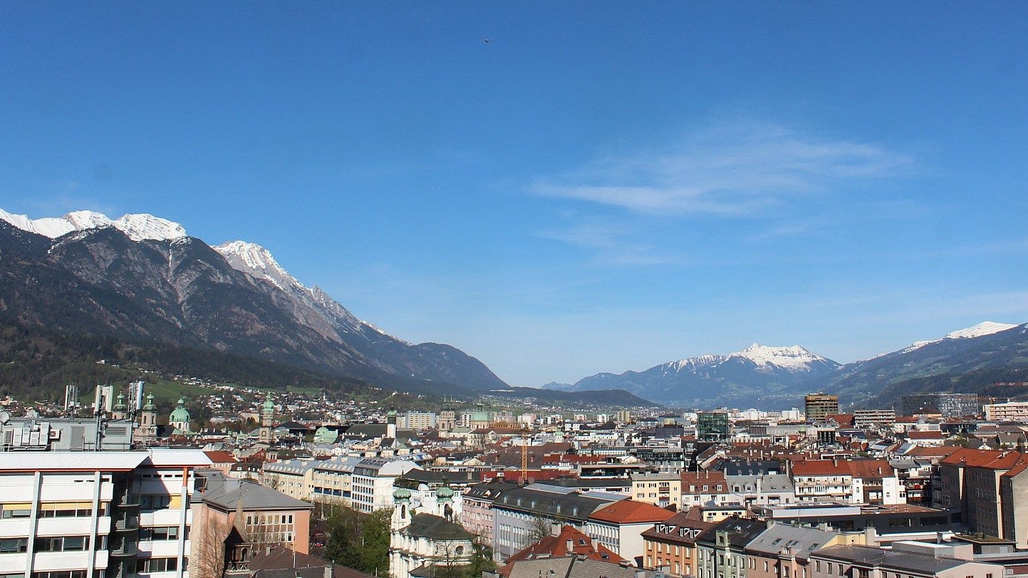 Blick vom Gebäude der Uni Innsbruck nach Nordosten ins Unterinntal am 6. April 2024. Die gezeigte Temperaturmessung stammt nicht von der offiziellen Wetterstation. Der Webcam-Sensor ist der Sonne ausgesetzt, deshalb höher.