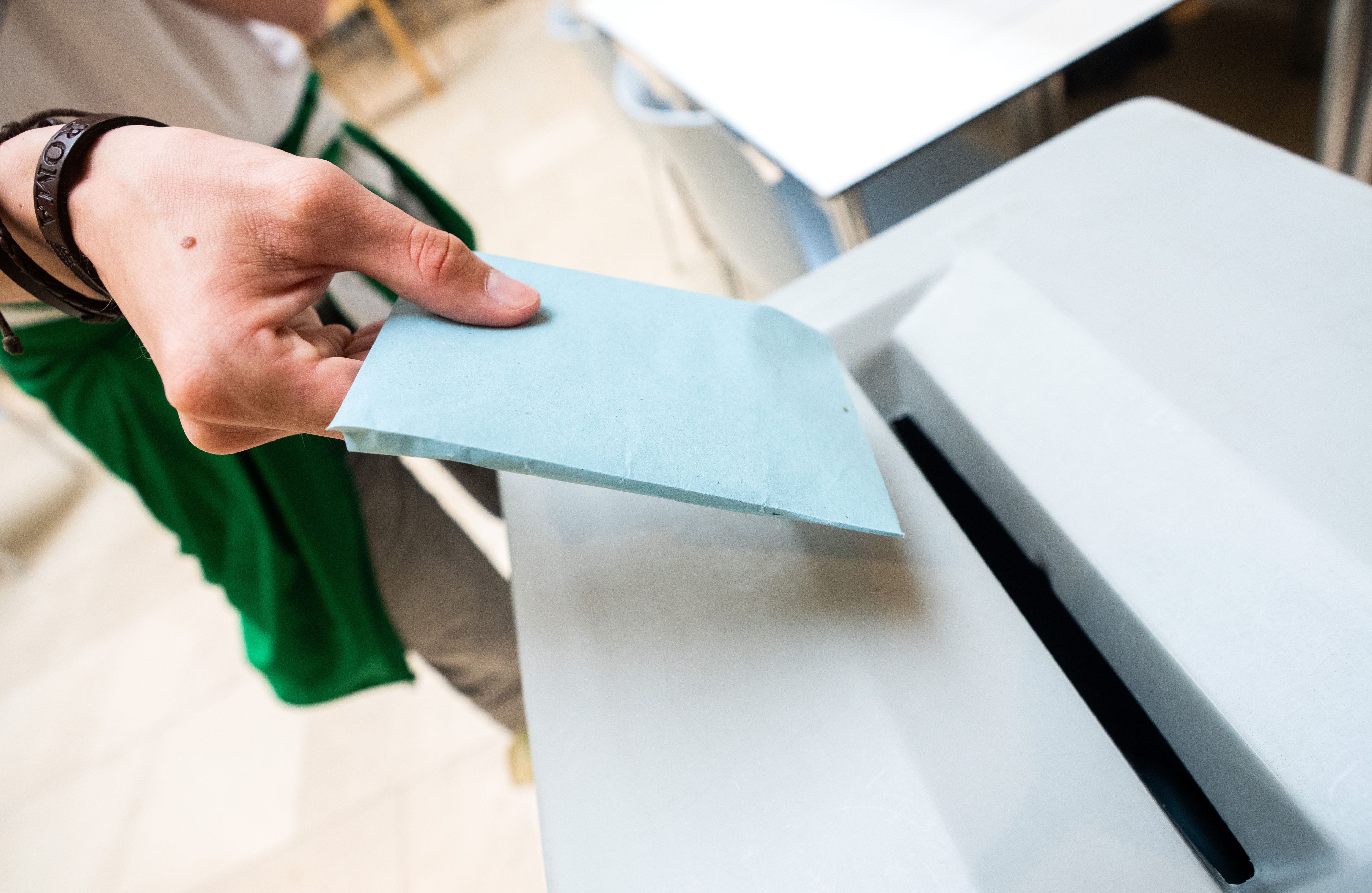 Einwurf eines Wahlzettels in eine Wahlurne. Symbolbild