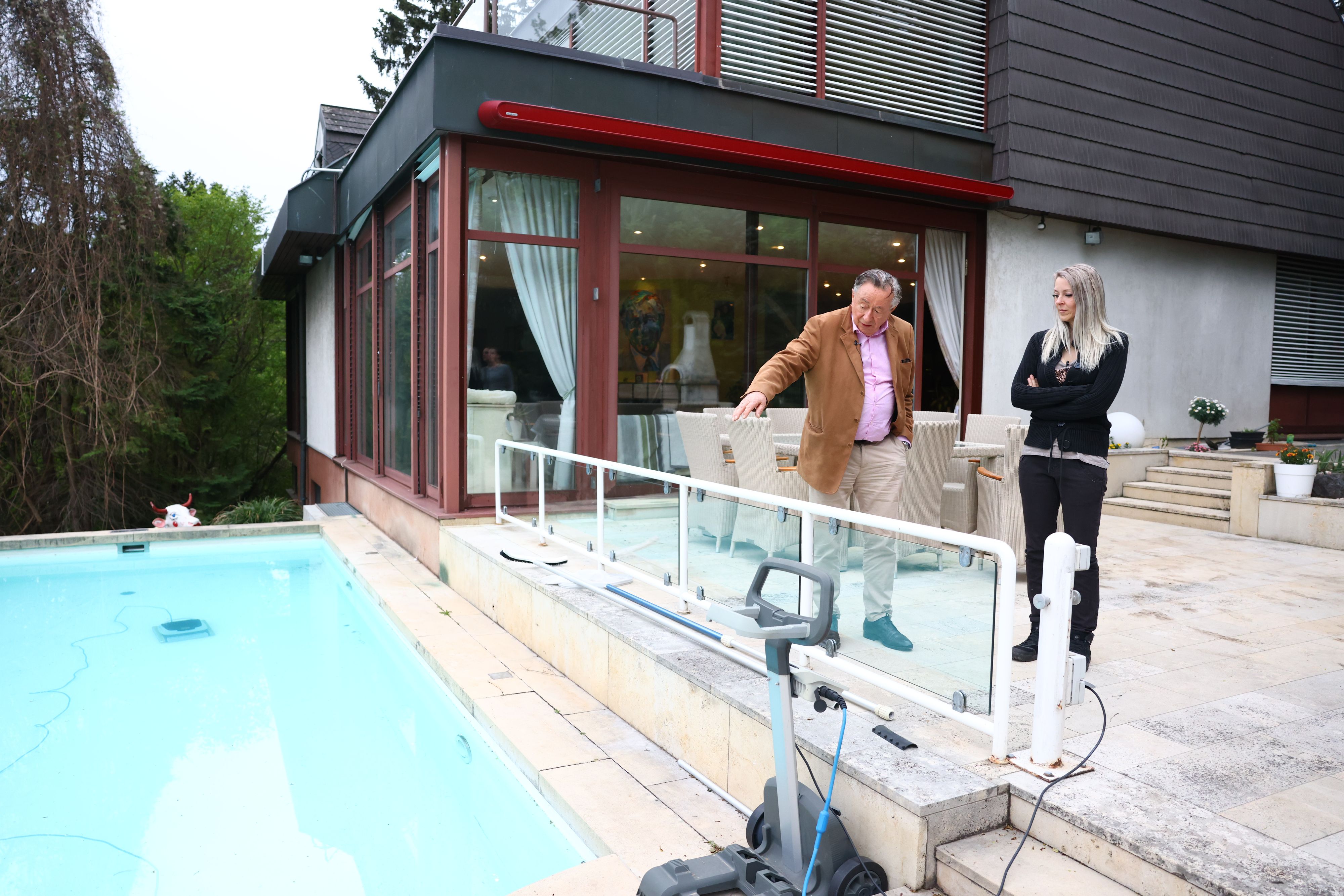 In den Pool hüpft Lugner ganzjährig, nach der Sauna. Hier erklärt der Baumeister seiner Simone, wie sie den Pool-Roboter bedienen soll.