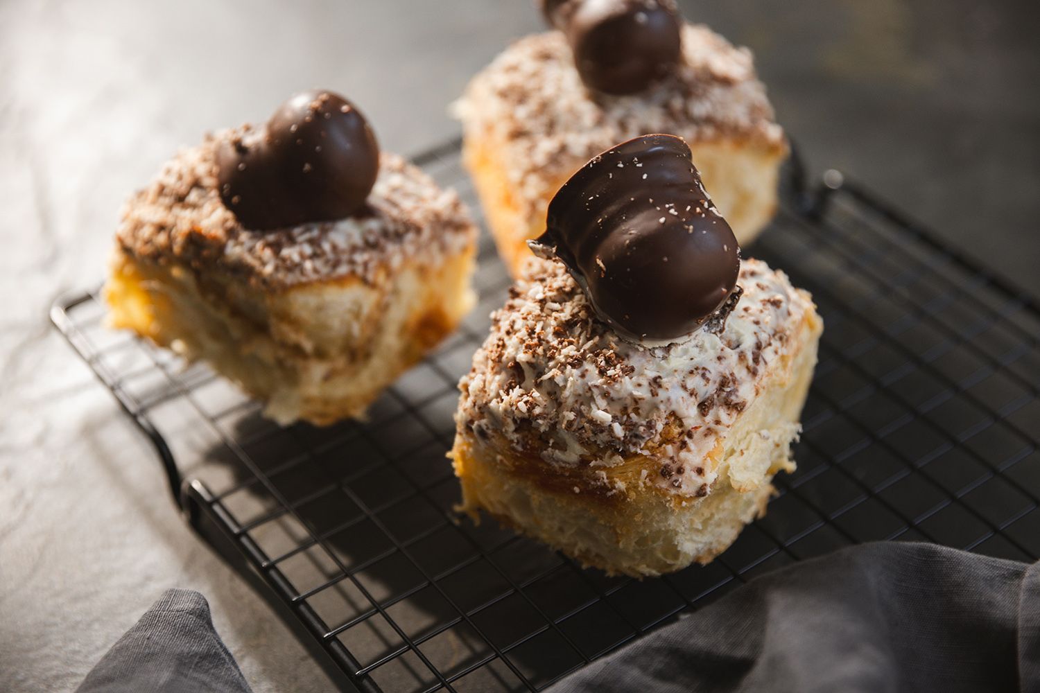 Der beliebte Butterplunderteig wird mit einer Kokosfülle bestrichen und zu einer Schnecke gerollt. Auf die weiße Schokoglasur kommt noch eine original Schwedenbombe.