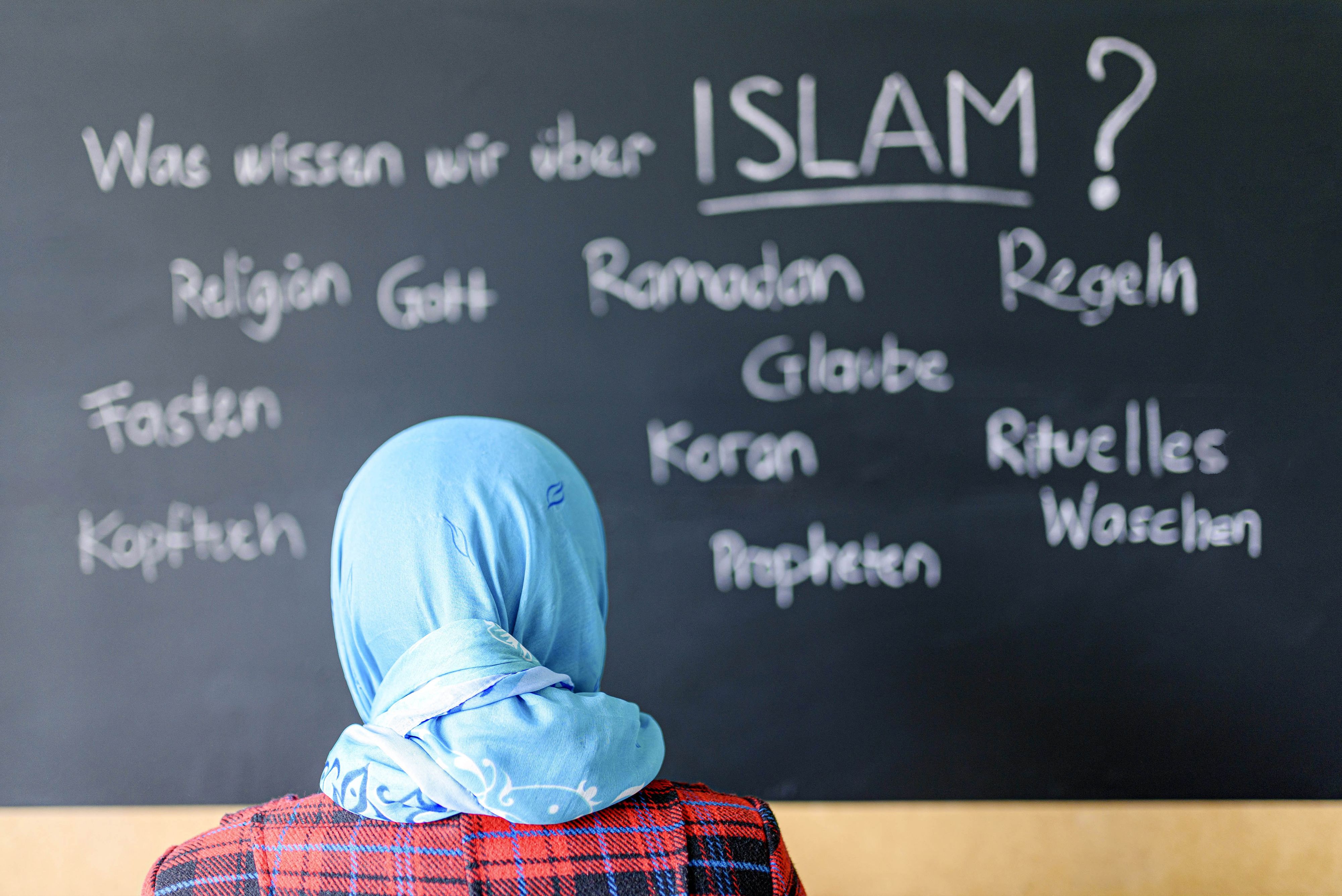 Eine muslimische Schülerin vor einer Tafel mit Begriffen aus dem Islam im Islamunterricht. (Symbolbild)