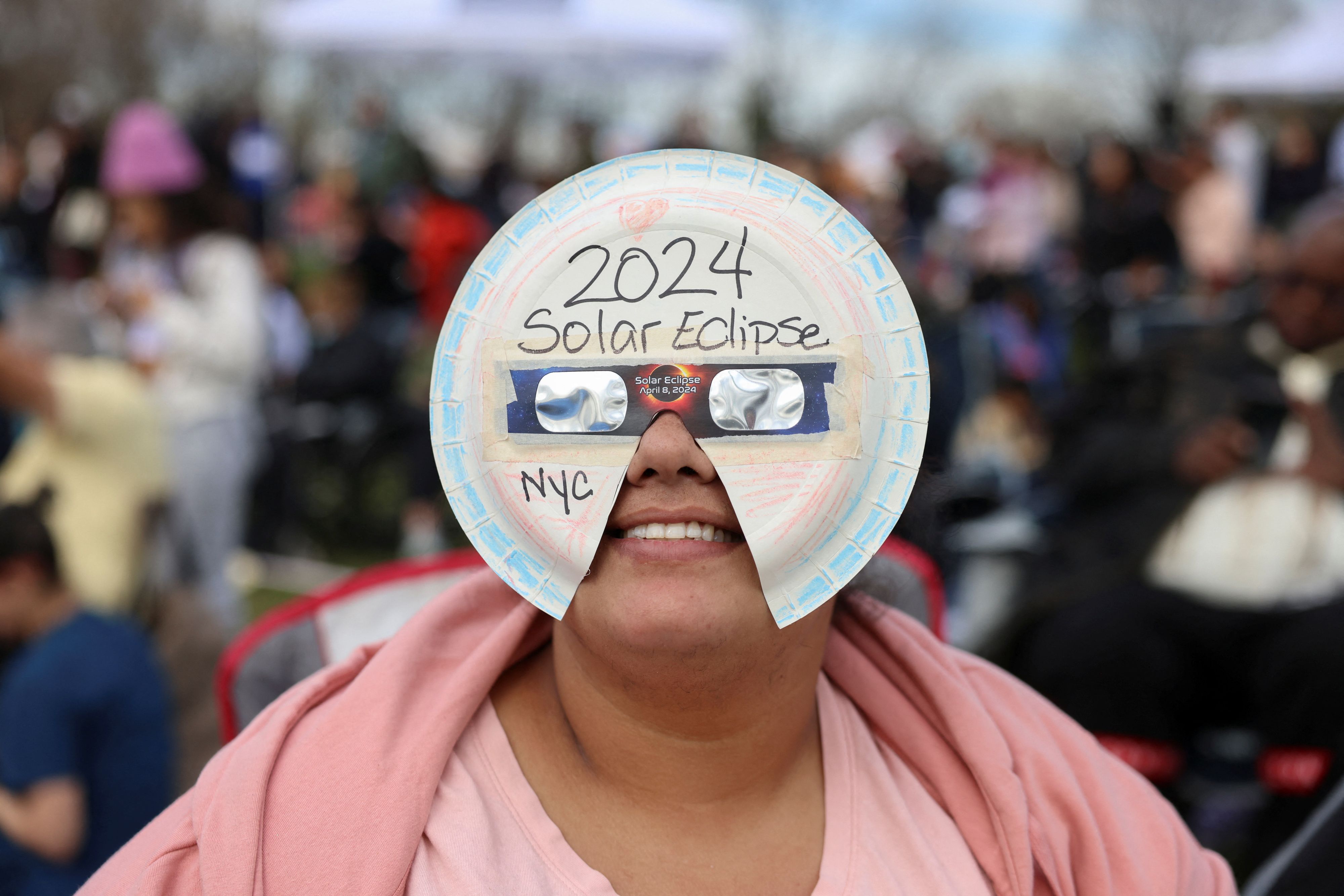 Local resident Sigrid Pena, 37, wears a homemade mask to view a partial solar eclipse at New York Hall of Science in Queens borough, New York City, U.S., April 8, 2024. REUTERS/Andrew Kelly