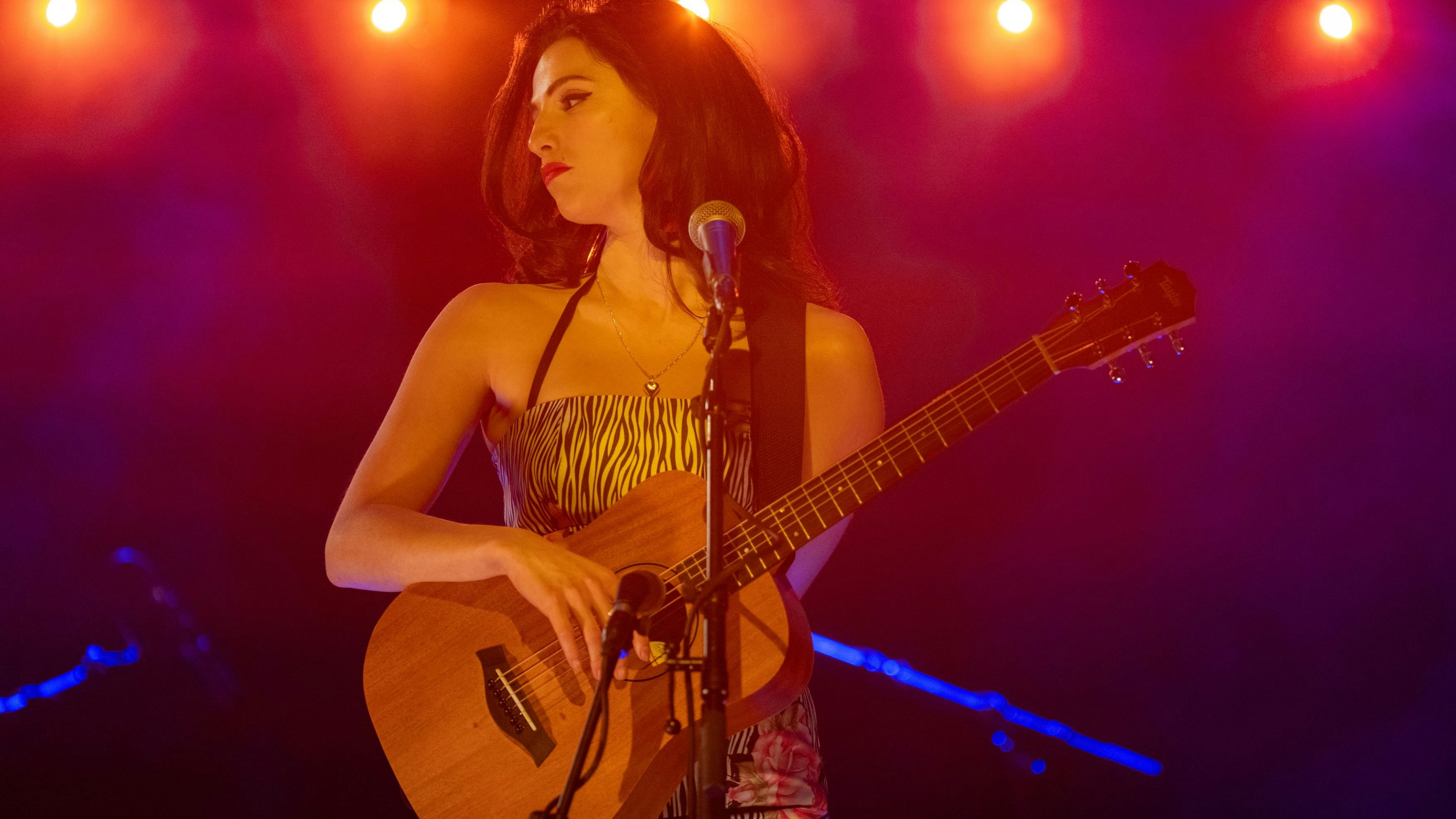Start als Solokünstlerin mit Gitarre: Ihr exzentrisches Äußeres mit Bienenstockfrisur und Lidstrich legte sich Amy Winehouse (Marisa Abela) erst später zu